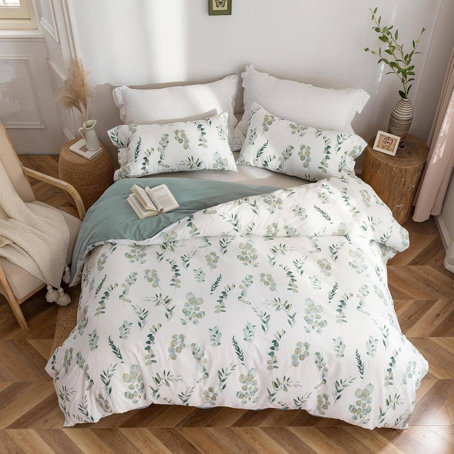 Ein gemütliches Schlafzimmer mit einem ordentlich gemachten Bett, das weiß-grüne Blumenbettwäsche trägt, ein Buch auf dem Bett liegt und eine Pflanze auf einem Holznachttisch steht.