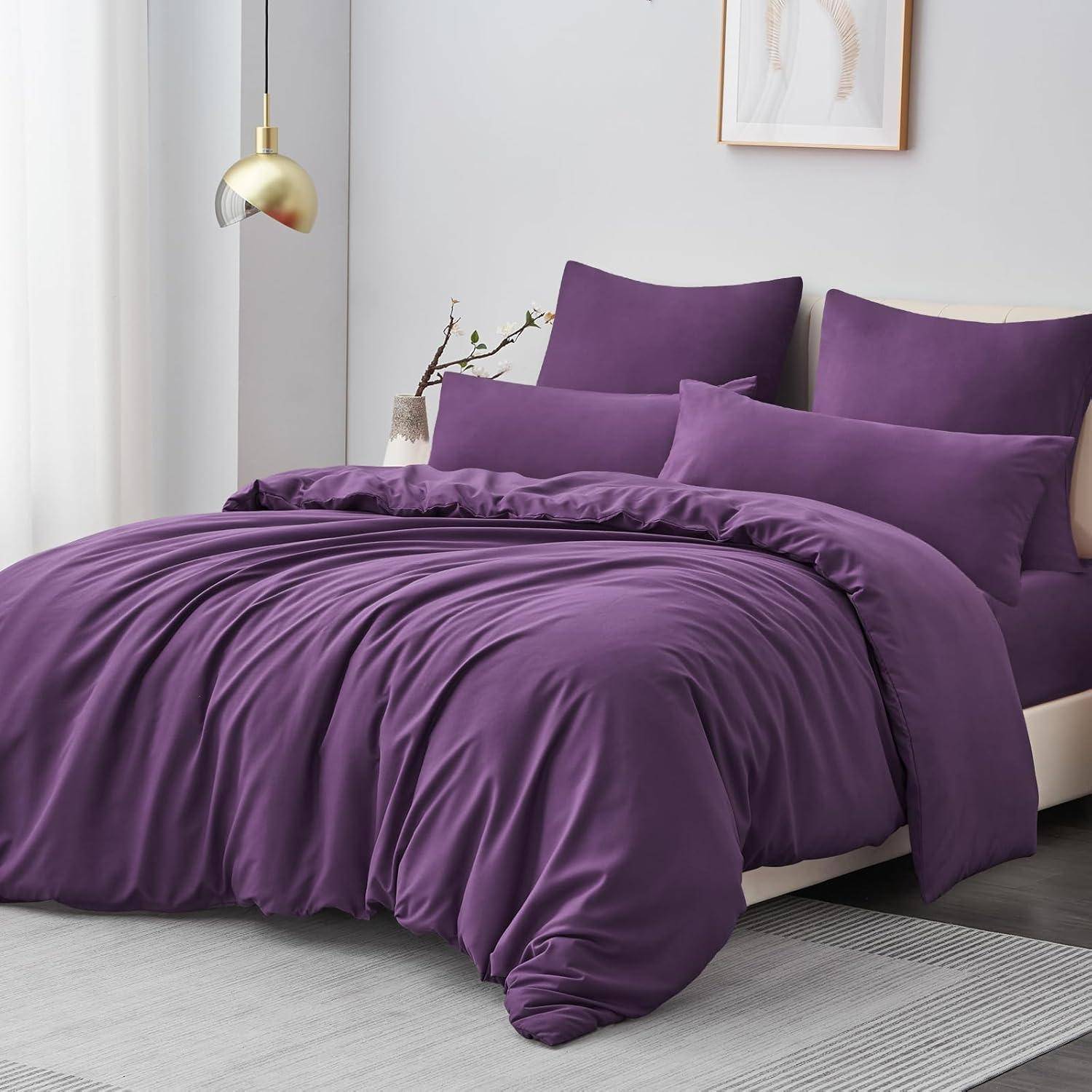 Lila Bettwäsche-Set auf einem ordentlich gemachten Bett, umgeben von einer goldenen Lampe und einfacher Dekoration in einem modernen Schlafzimmer.