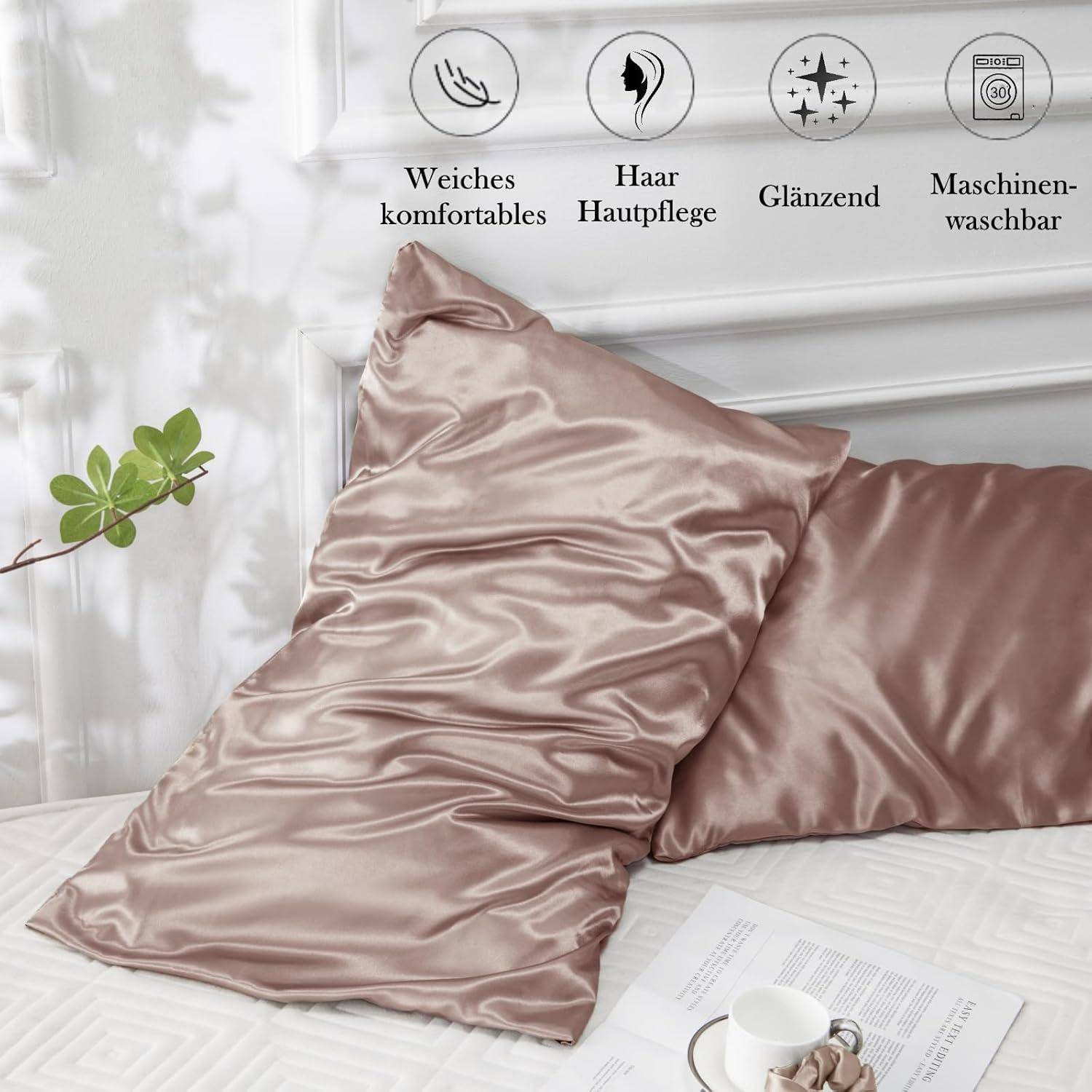 Zwei seidenmatte Kissenbezüge auf einem Bett, mit Icons darüber, die Eigenschaften hervorheben: weich, Haarpflege, glänzend, maschinenwäschetauglich.