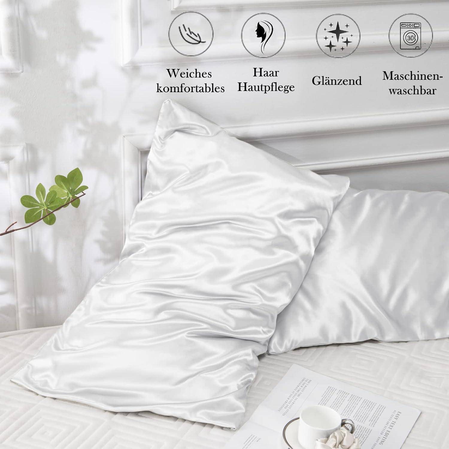 Eine Seidenkissenhülle auf einem Bett mit einer Pflanze und einem Buch in der Nähe. Symbole darüber zeigen an, dass sie weich, für die Haarpflege geeignet, glänzend und maschinell waschbar ist.