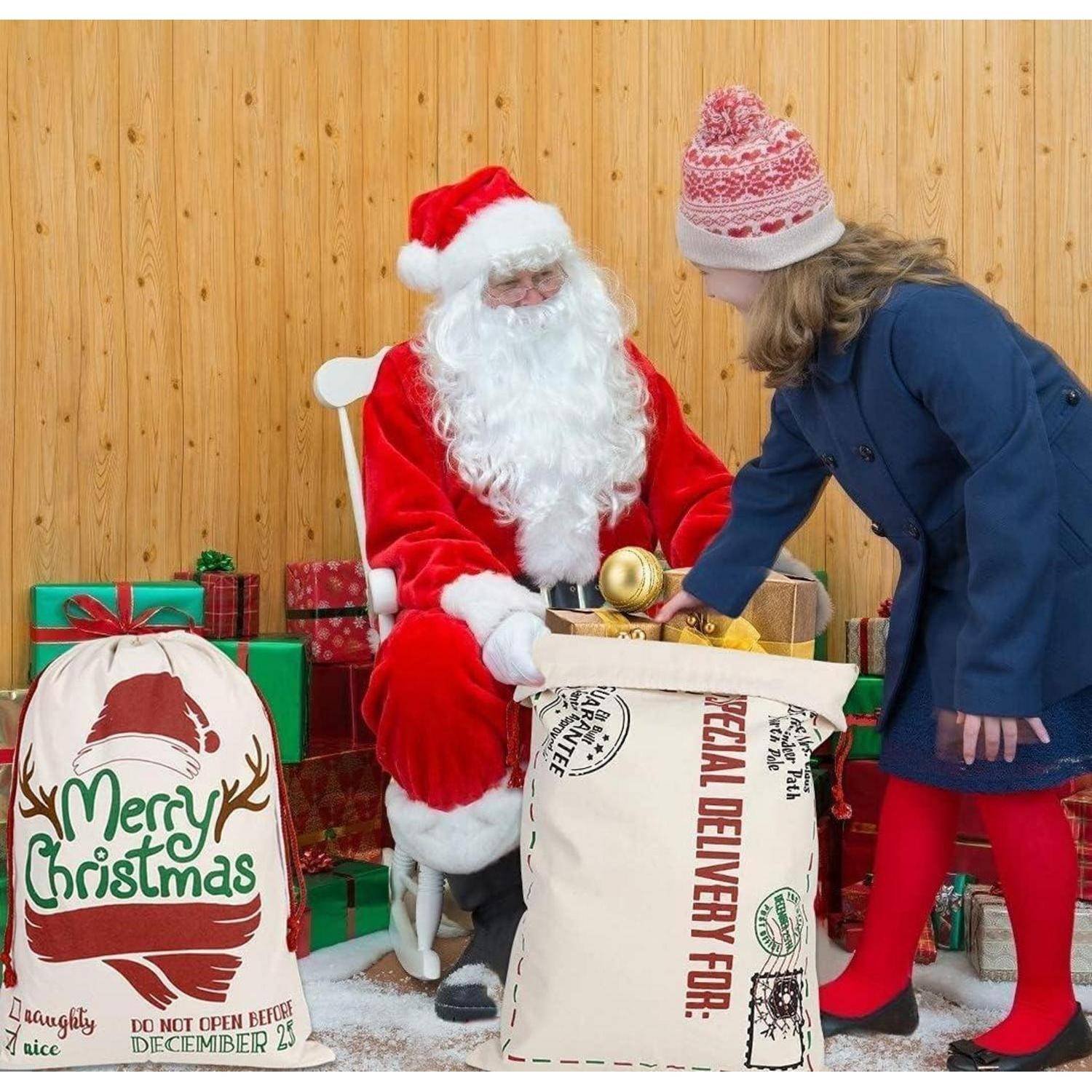 Eine Person, gekleidet als Weihnachtsmann, sitzt auf einem Stuhl, während ein Kind in einem Mantel und Hut ihm ein Geschenk überreicht. Große Geschenktüten sind mit 