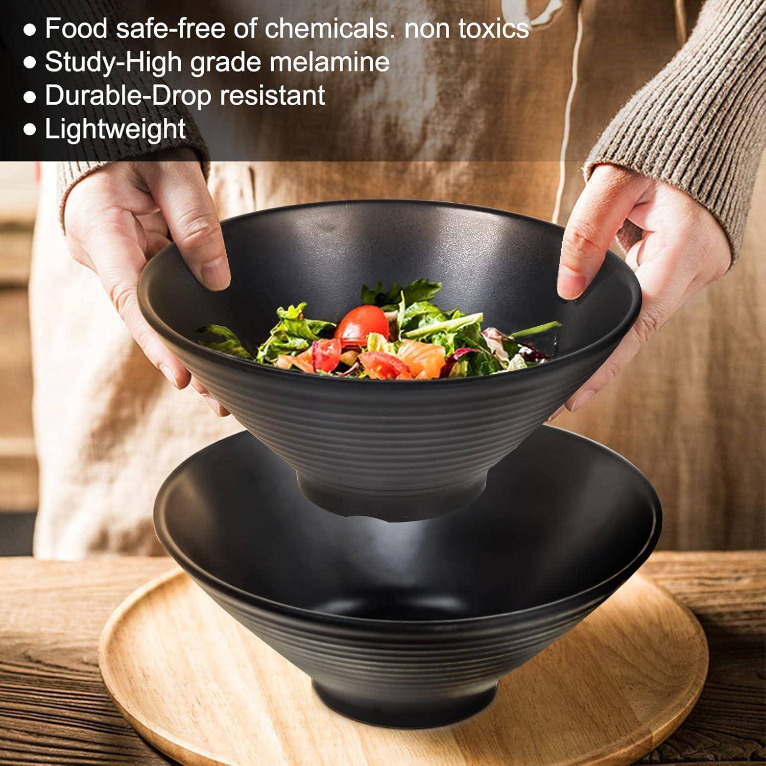 Eine Person hält eine schwarze Schüssel mit Salat. Text listet Eigenschaften auf: 'Lebensmittelecht, chemikalienfrei, ungiftig, robustes Melamin, langlebig, leicht.