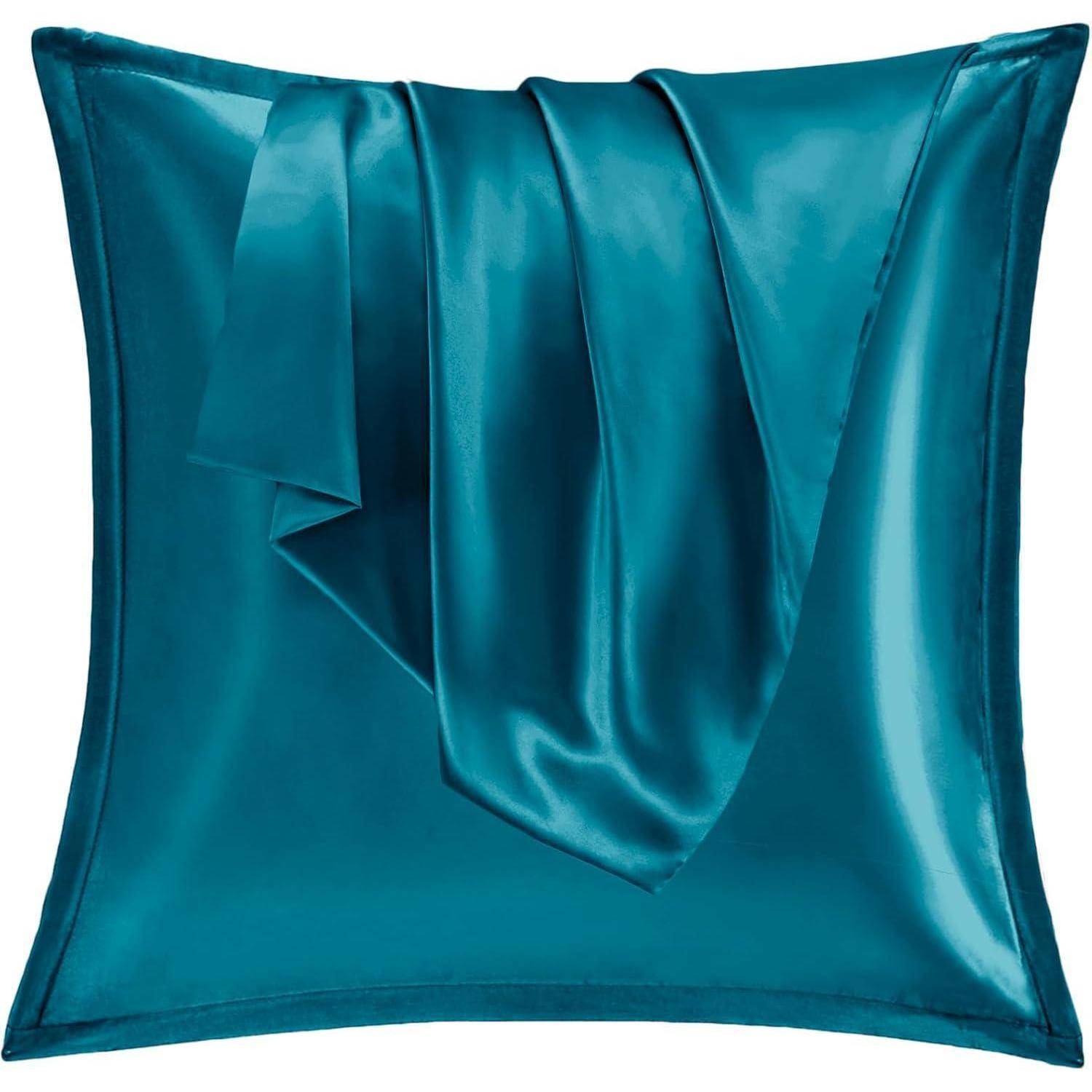 Ein glänzendes petrolblaues Satin-Kissen mit einem passenden Satin-Überwurf, der elegant darauf gefaltet ist und die glatte und glänzende Gewebestruktur zur Schau stellt.