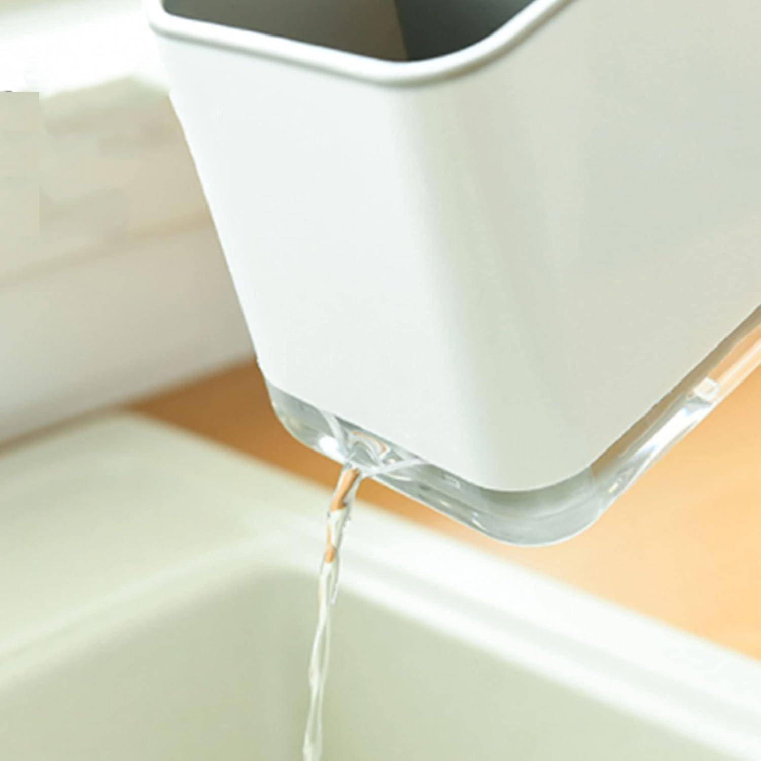 Wasser gießt aus einem weißen Behälter in ein Waschbecken und unterstreicht ein minimalistisches und klares Design in einer modernen Küchenumgebung.