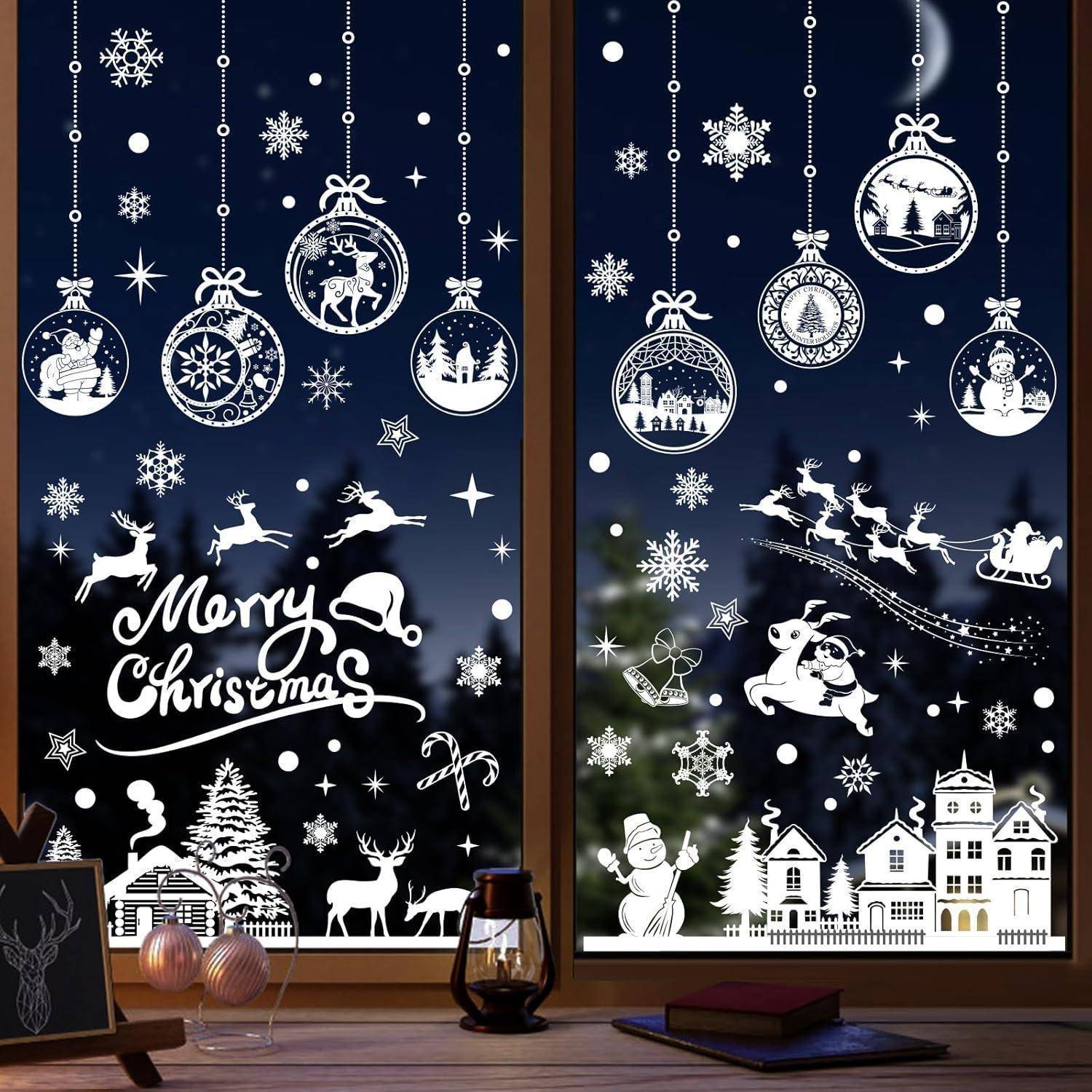 Das Bild zeigt festliche Weihnachtsfensteraufkleber mit Schneeflocken, Rentieren und einem 'Frohe Weihnachten'-Schriftzug vor einem nächtlichen Himmel.