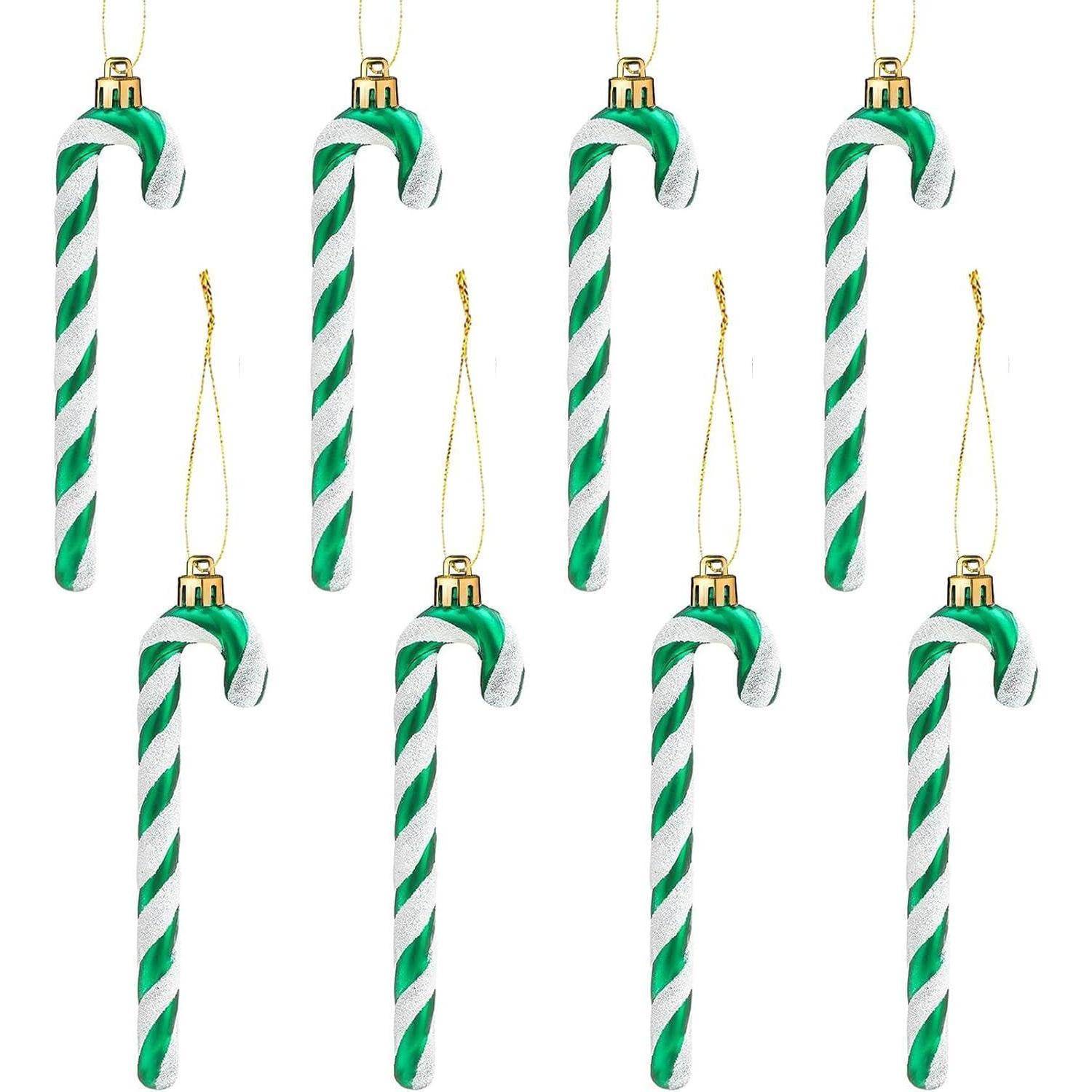 Acht grün-weiß gestreifte Zuckerstangen-Anhänger mit goldenen Kappen und Aufhängeschlaufen, in zwei Reihen von je vier angeordnet.