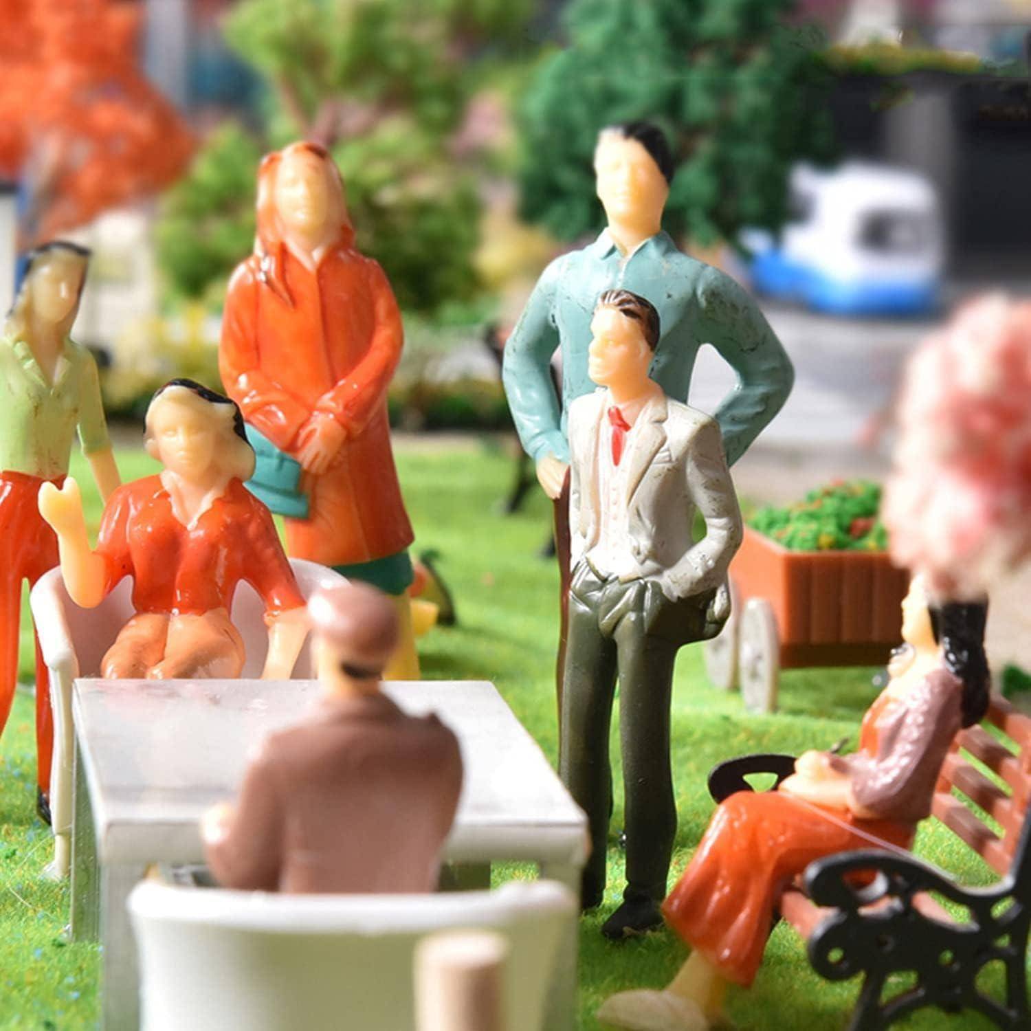 Eine Diorama-Szene mit Miniatur-Figuren, die an einem Tisch in einer Parklandschaft eine Unterhaltung führen.