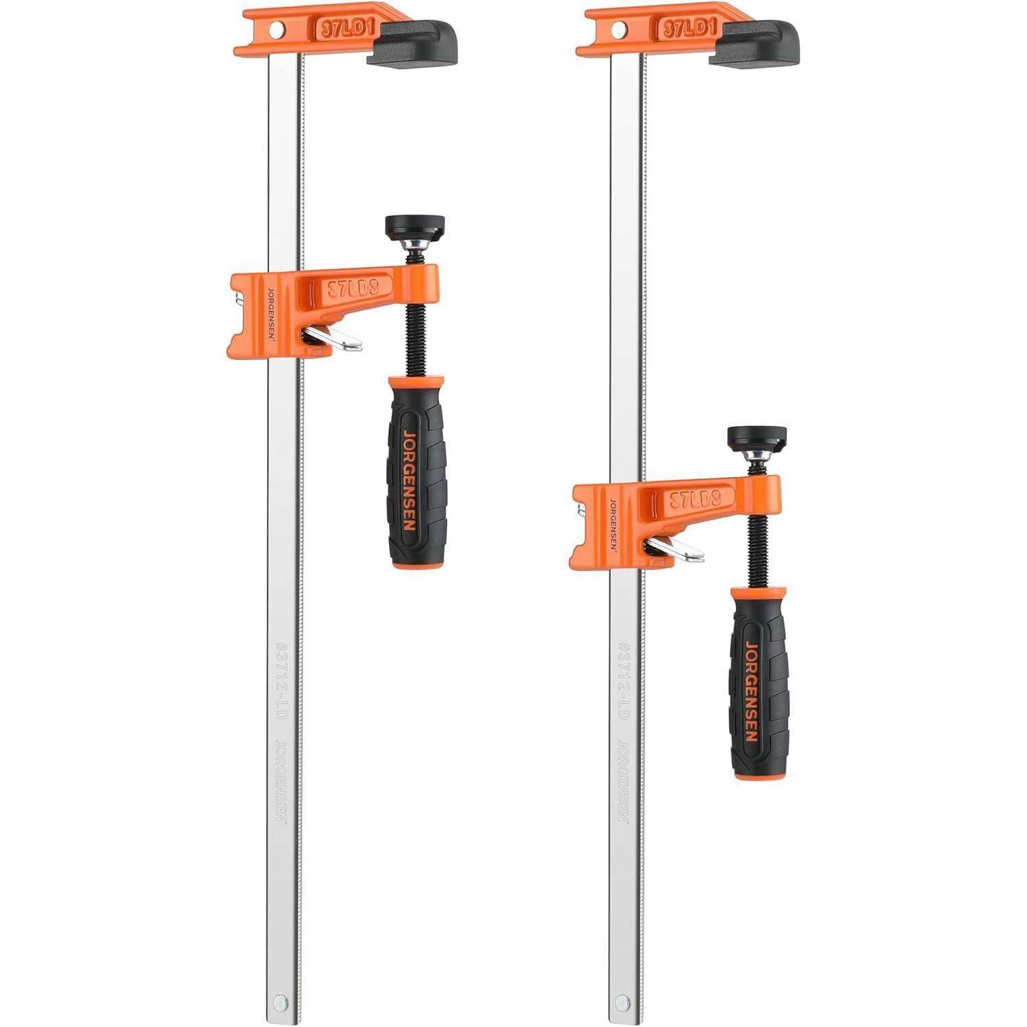 Zwei orange und schwarze Schraubzwingen mit Metallstangen, die zum Festhalten oder Sichern von Gegenständen während Holz- oder Metallarbeiten verwendet werden.