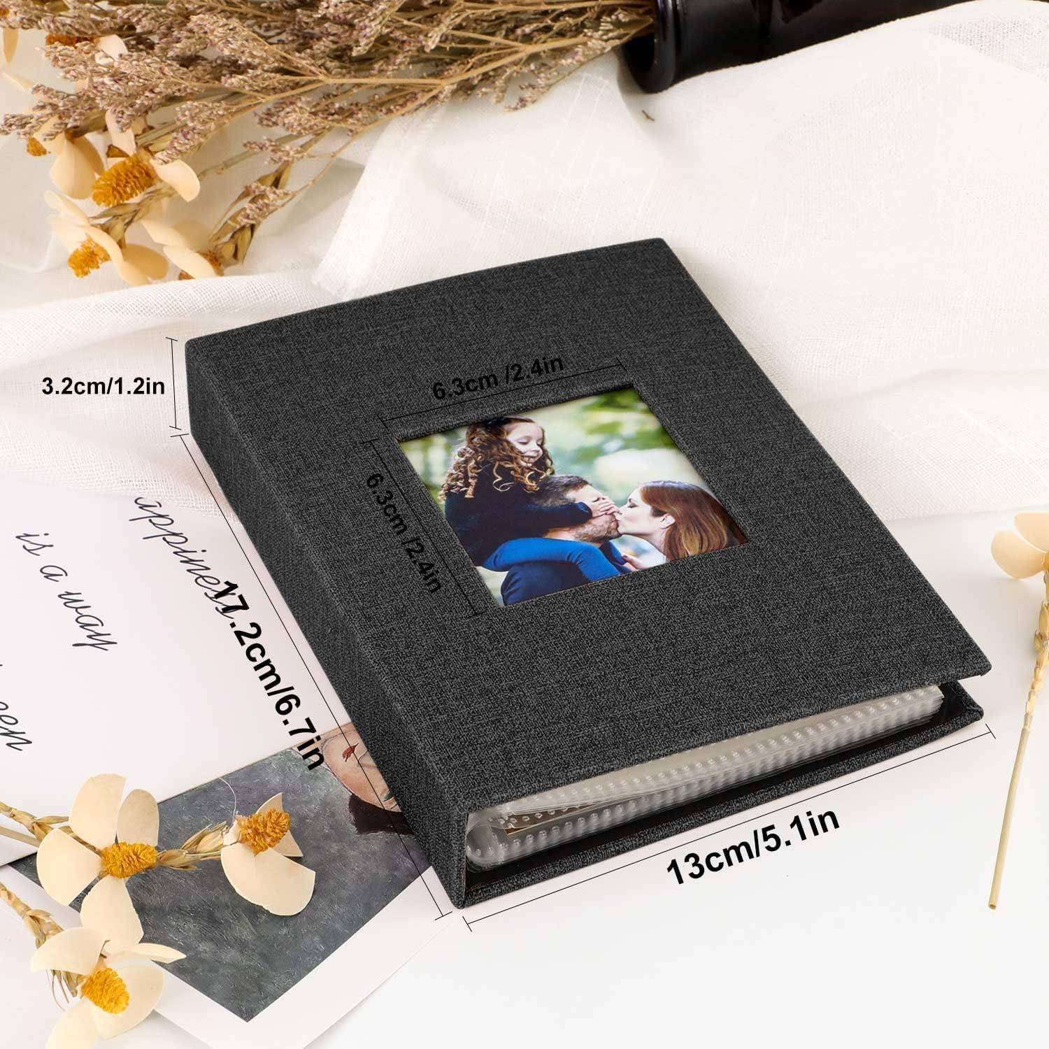 Ein schwarzes Fotoalbum liegt auf einem Tisch und zeigt auf dem Einband ein Familienfoto sowie Größenangaben: 13 cm x 5,1 Zoll, 6,3 cm x 2,4 Zoll.