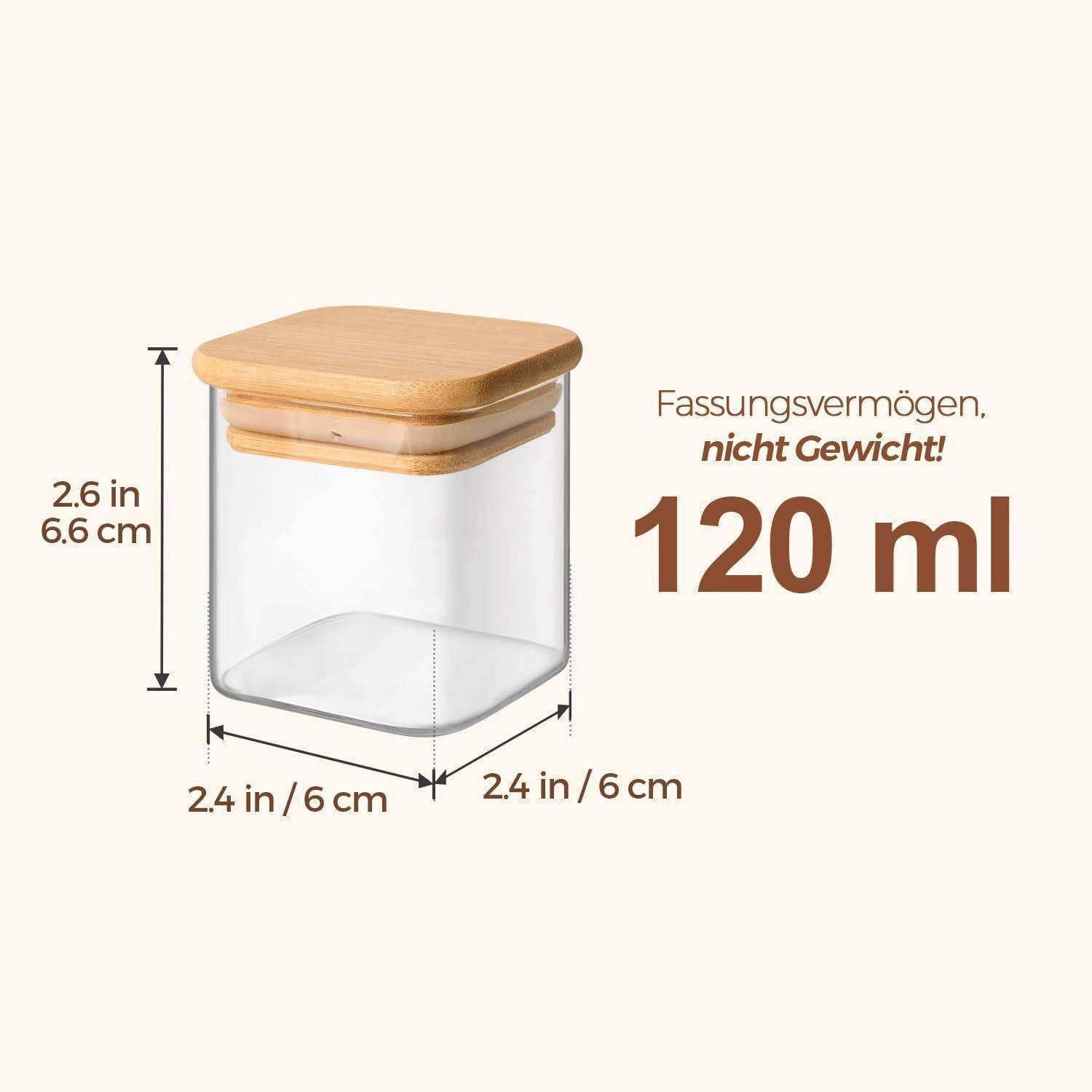 Ein transparenter rechteckiger Behälter mit einem Holzdeckel, der 2,4 Zoll/6 cm pro Seite misst, mit einer Höhe von 2,6 Zoll/6,6 cm, mit einem Fassungsvermögen von 120 ml.