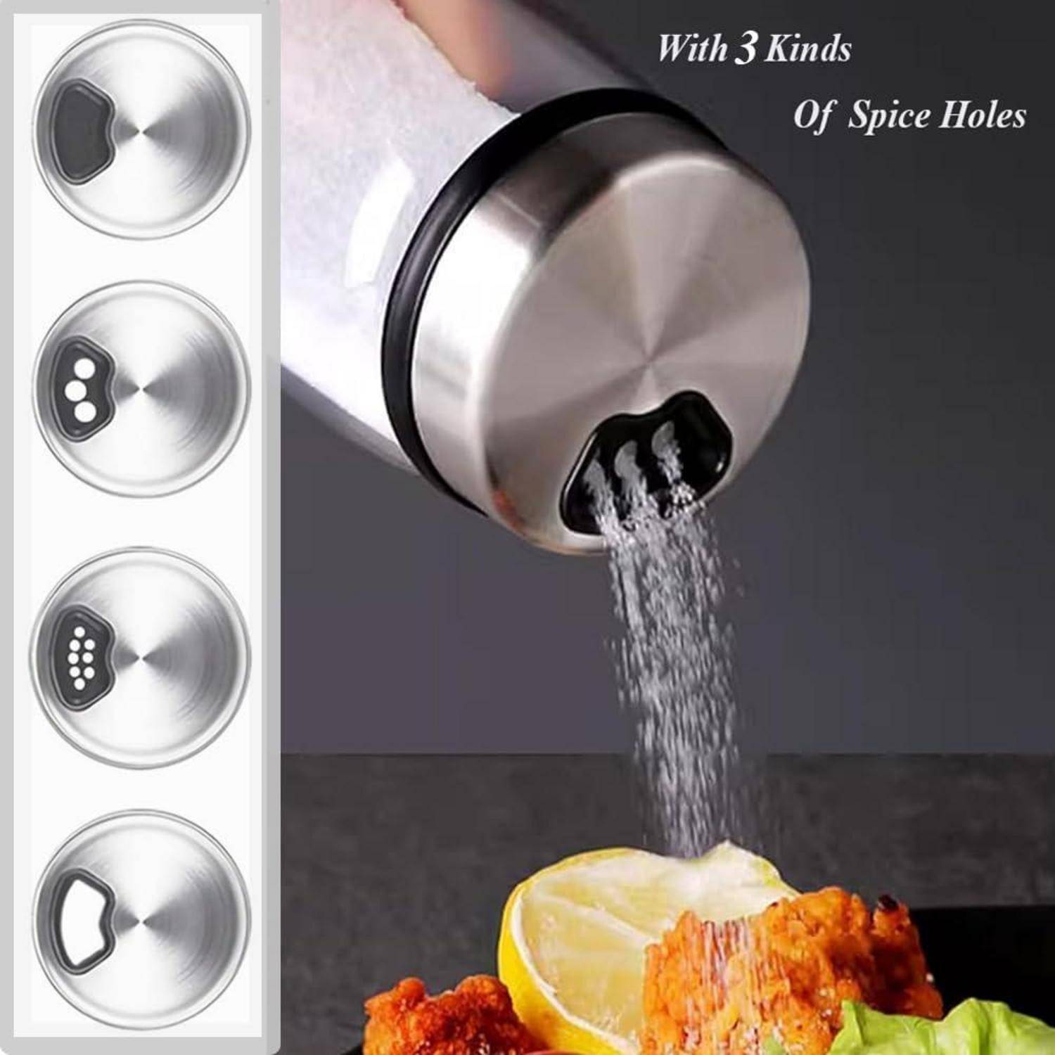 Ein Metallsalzstreuer mit auswechselbaren Deckel für unterschiedliche Ausschüttmengen wird verwendet, um Salz auf gekochtes Essen neben einer Zitronenscheibe zu streuen.
