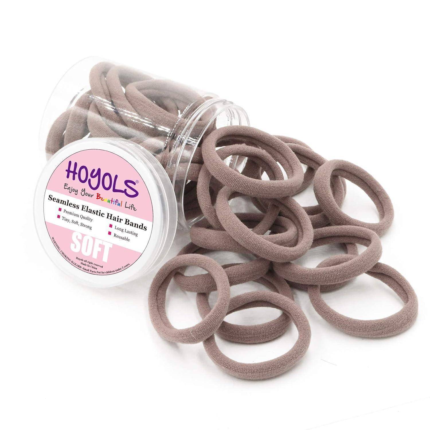 Ein durchsichtiges Glas mit einem rosa Etikett, beschriftet mit „Hoyols: Nahtlose Elastische Haarbänder