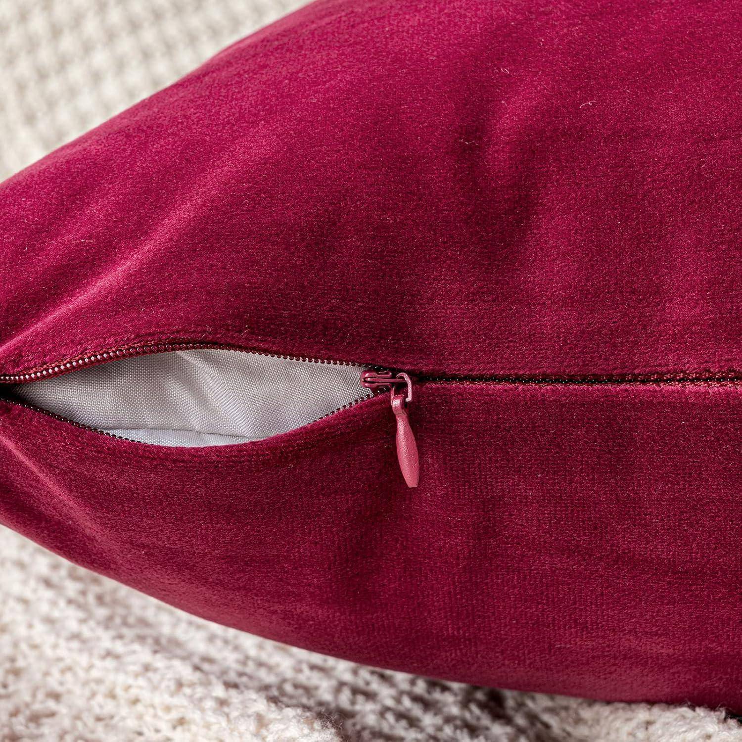 Ein roter Kissen mit einem teilweise geöffneten Reißverschluss, der die weiße Innenfütterung enthüllt, auf einer strukturierten Oberfläche platziert.