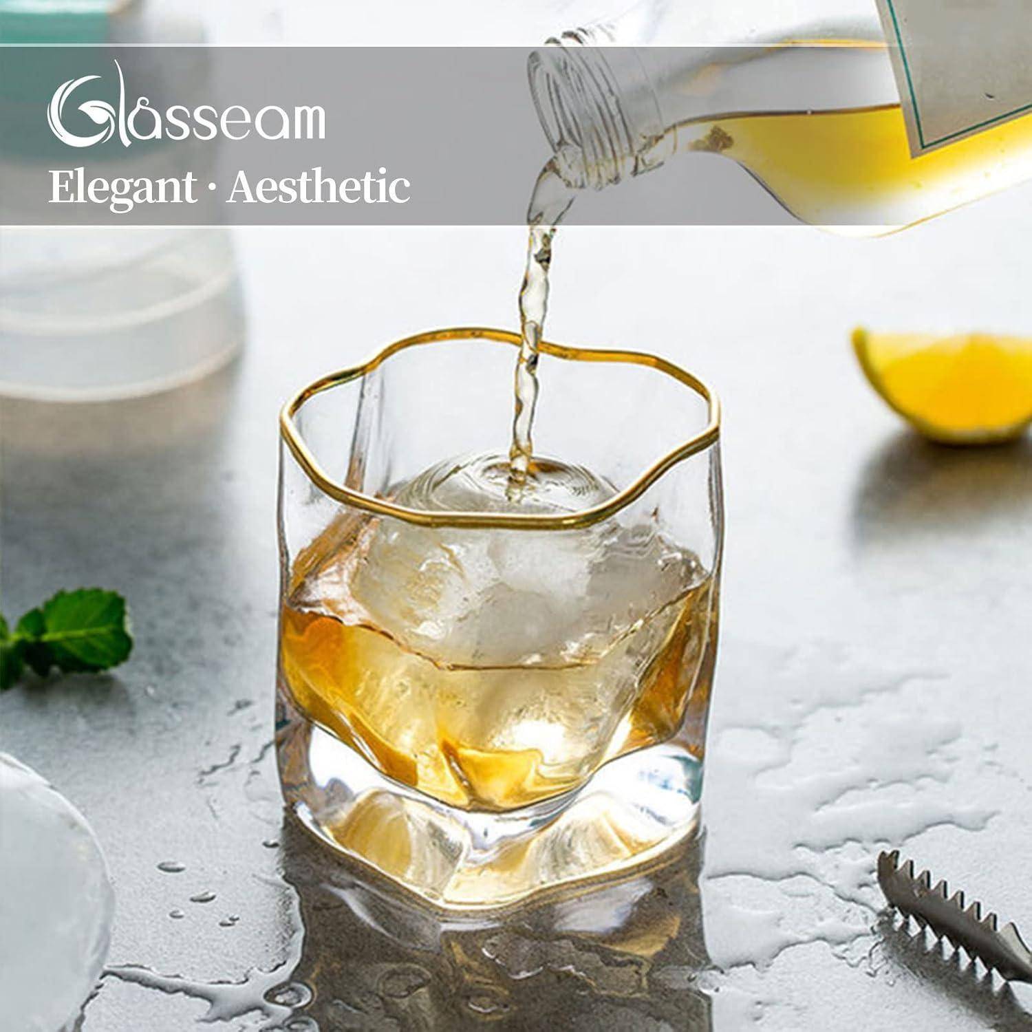 Ein Glas mit einem großen Eiswürfel wird mit einem hellen Getränk gefüllt, eine Zitronenscheibe liegt daneben; Text liest sich 