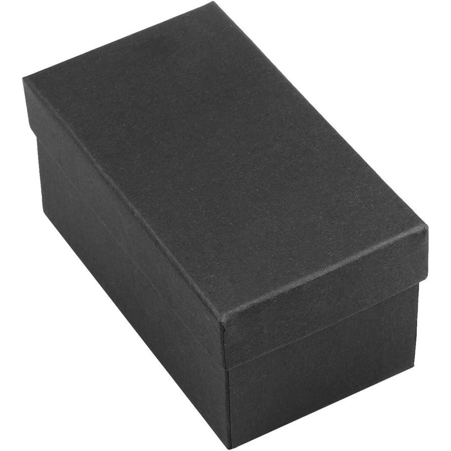 Eine geschlossene schwarze Schuhbox aus Karton in rechteckiger Form, die auf einer weißen Oberfläche liegt.