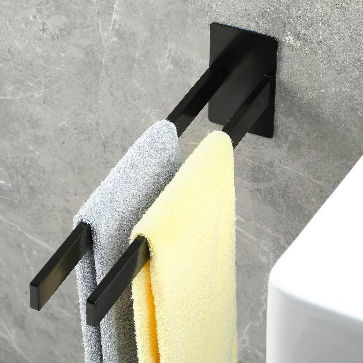An einer schwarzen, an der Wand befestigten Handtuchhalterung hängen ein graues und ein gelbes Handtuch, mit einem schlichten, modernen Design vor einer strukturierten grauen Wand in der Nähe einer weißen Oberfläche.