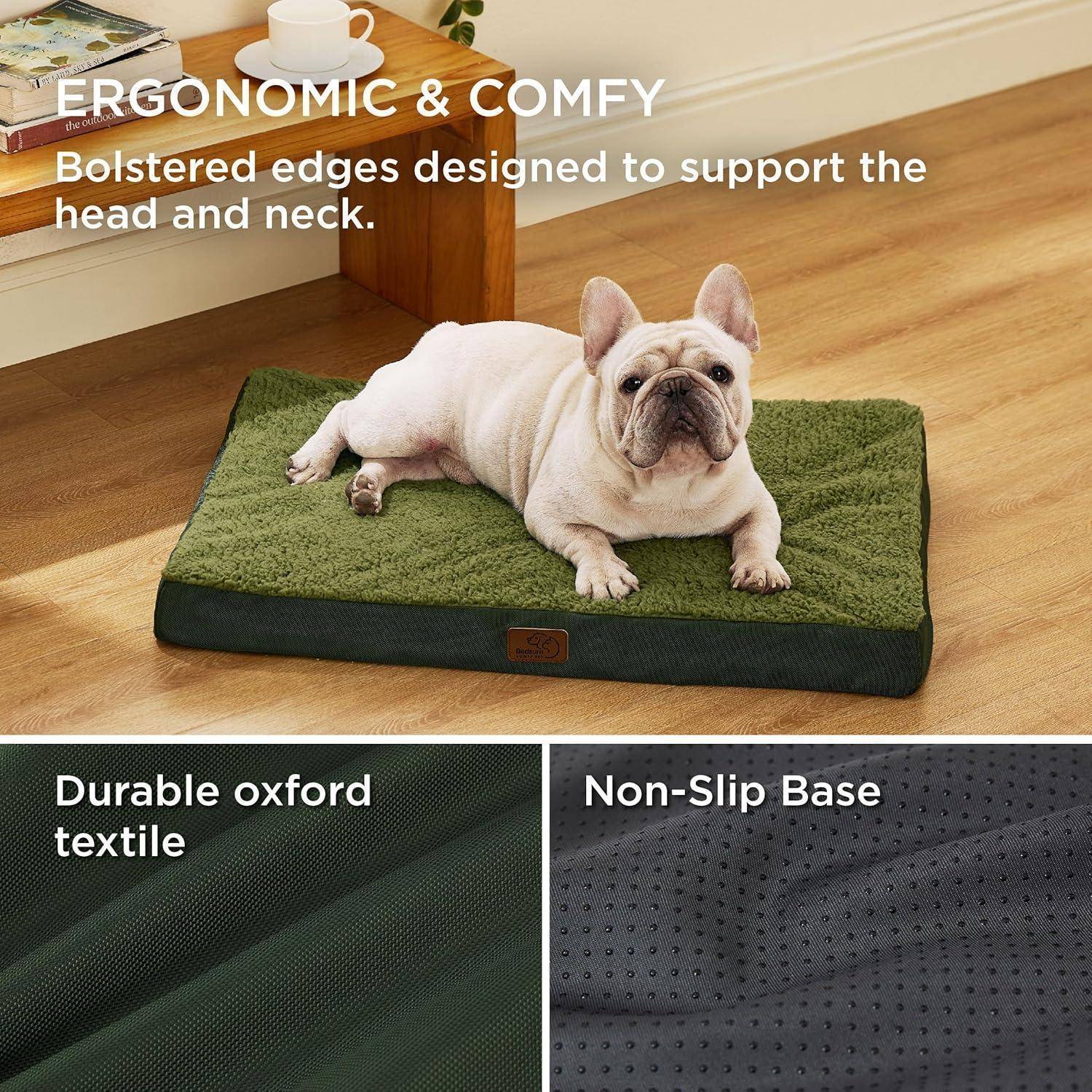 Ein Französische Bulldogge ruht auf einem grünen, gepolsterten Haustierbett mit erhöhten Kanten. Text hebt hervor: 'Ergonomisch & Bequem', 'Strapazierfähiger Oxford-Stoff' und 'Rutschfeste Unterseite'.