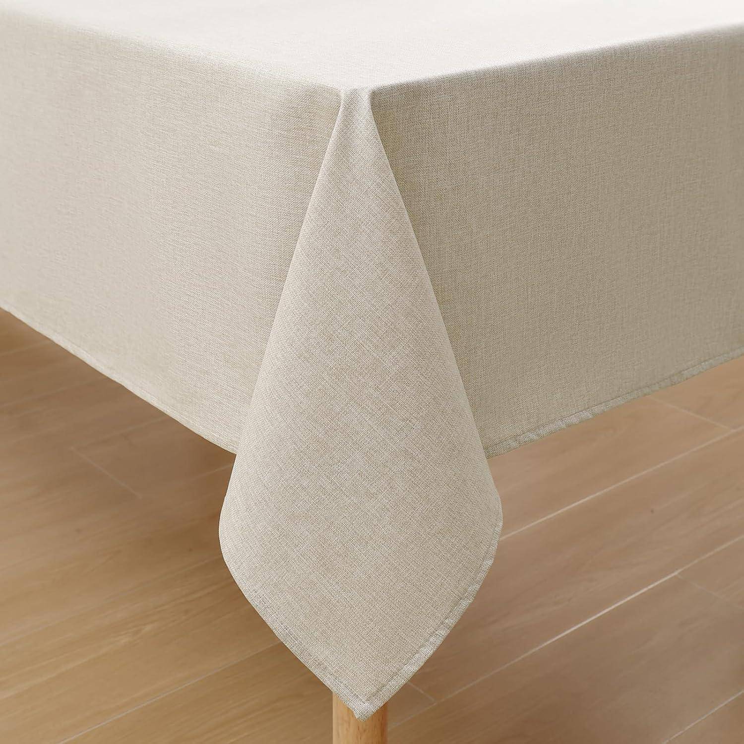 Eine beige Tischdecke, die über einen Holztisch drapiert ist und eine klare und schlichte Atmosphäre schafft. Die Textur wirkt glatt und makellos angepasst.