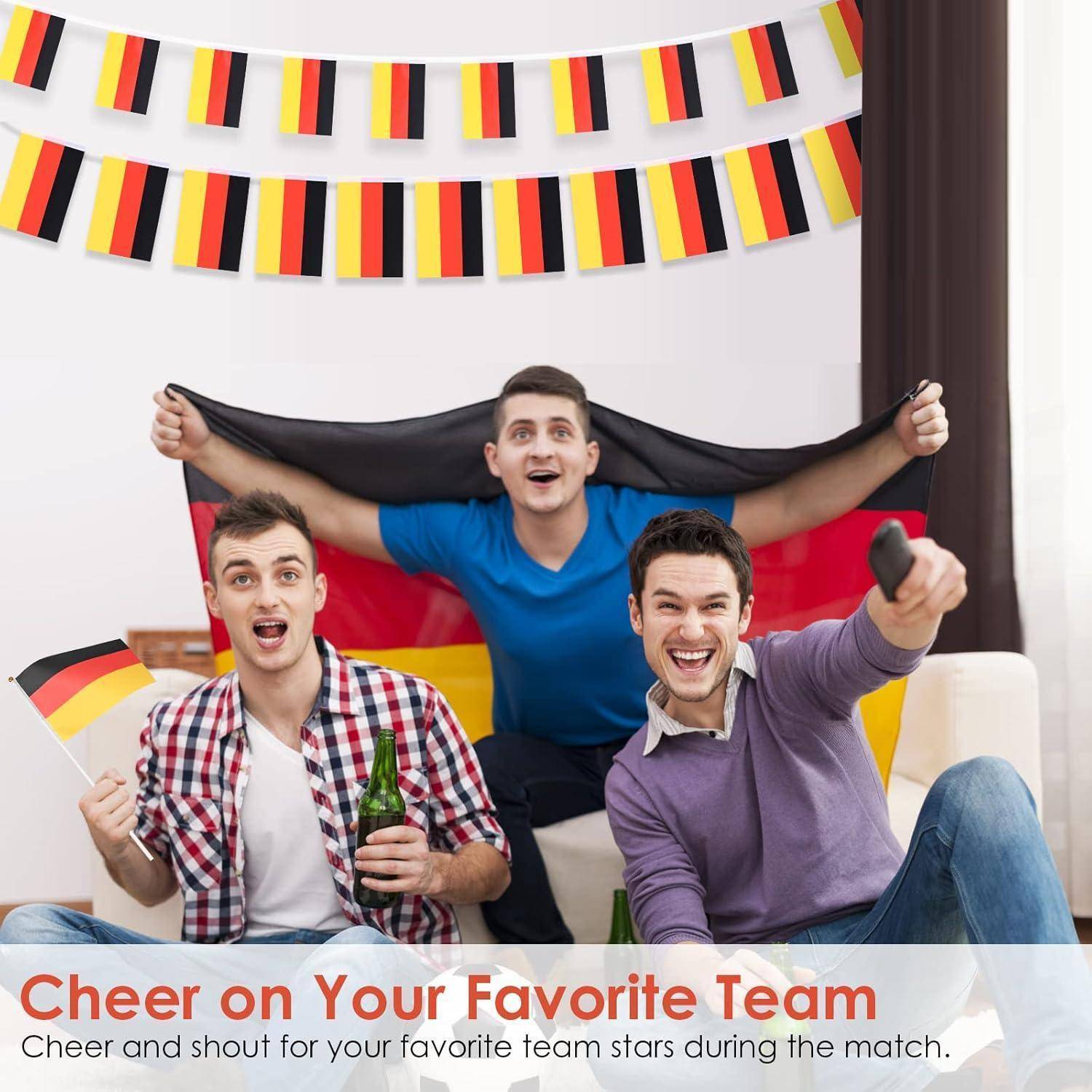 Drei Menschen sitzen auf einem Sofa, jubeln und halten Flaggen in den Farben der deutschen Nationalflagge. Text lautet: 