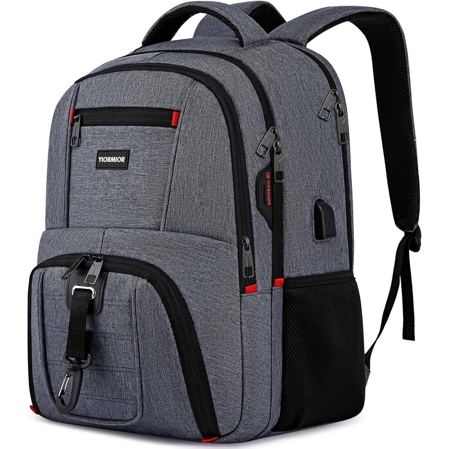 Ein grauer Rucksack mit mehreren Fächern, schwarzen Reißverschlüssen und roten Akzenten, ausgestattet mit gepolstertem Rücken und Schultergurten für optimalen Tragekomfort.