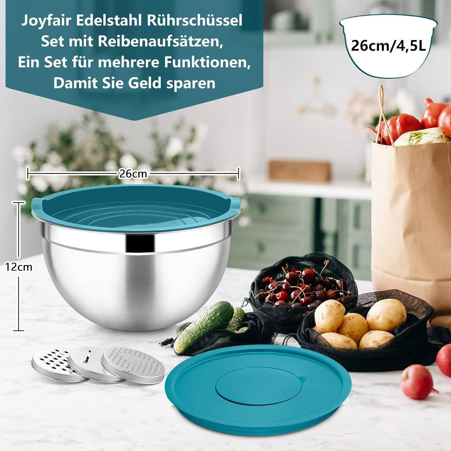 Ein Rührschüssel-Set umfasst eine große Schüssel aus Edelstahl mit einem türkisfarbenen Deckel, drei Reiberaufsätzen und einem kleineren türkisfarbenen Deckel. Früchte befinden sich in der Nähe.