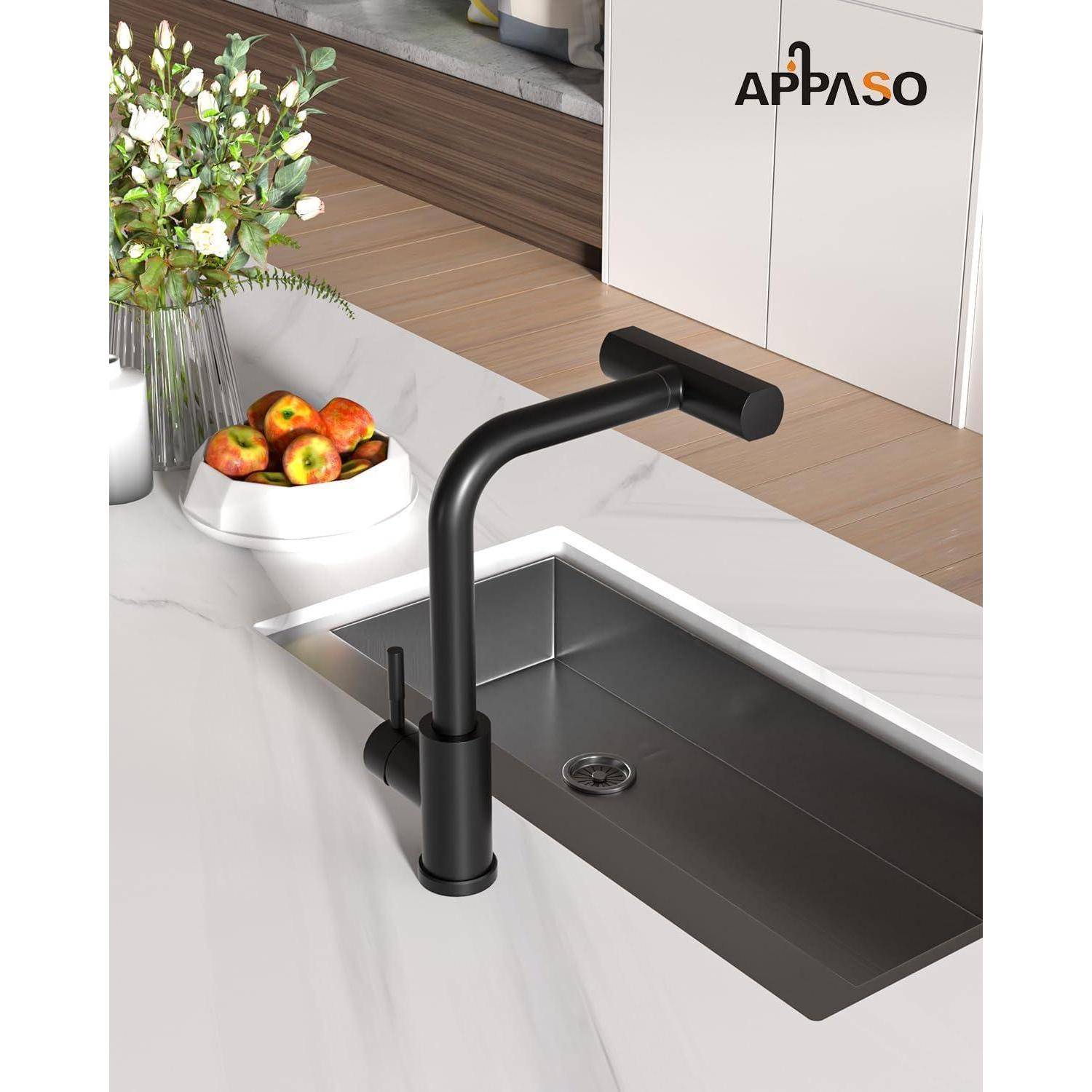 Küche mit Spüle und elegantem schwarzem Wasserhahn auf weißer Arbeitsplatte; Vase mit Blumen und eine Schüssel Äpfel im Hintergrund.