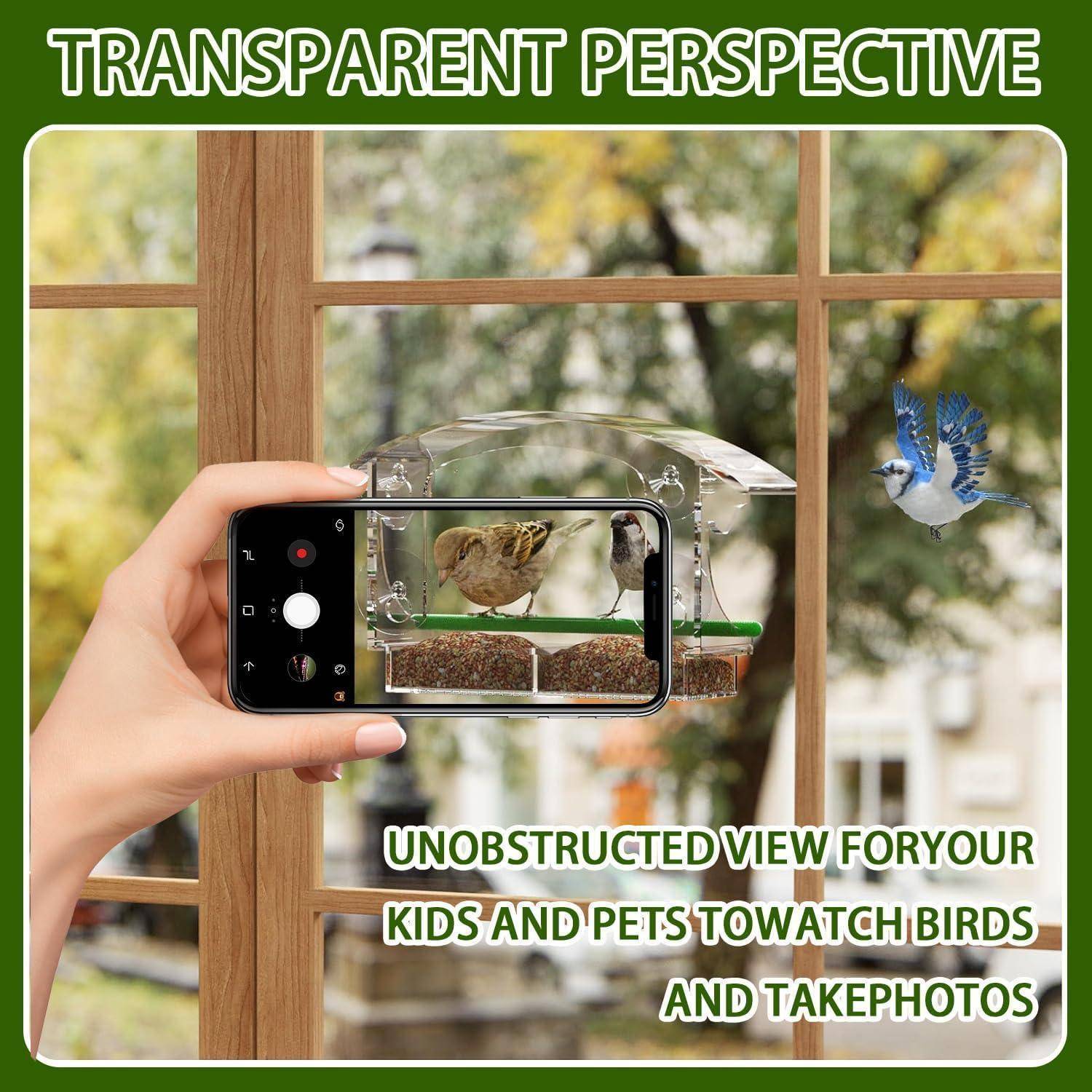 Eine Hand hält ein Telefon, um Vögel an einem Fenster-Vogelfutterhäuschen zu fotografieren. Text lautet: ‚Transparente Perspektive' und ‚Ungehinderte Sicht für Ihre Kinder und Haustiere, um Vögel zu beobachten und Fotos zu machen.