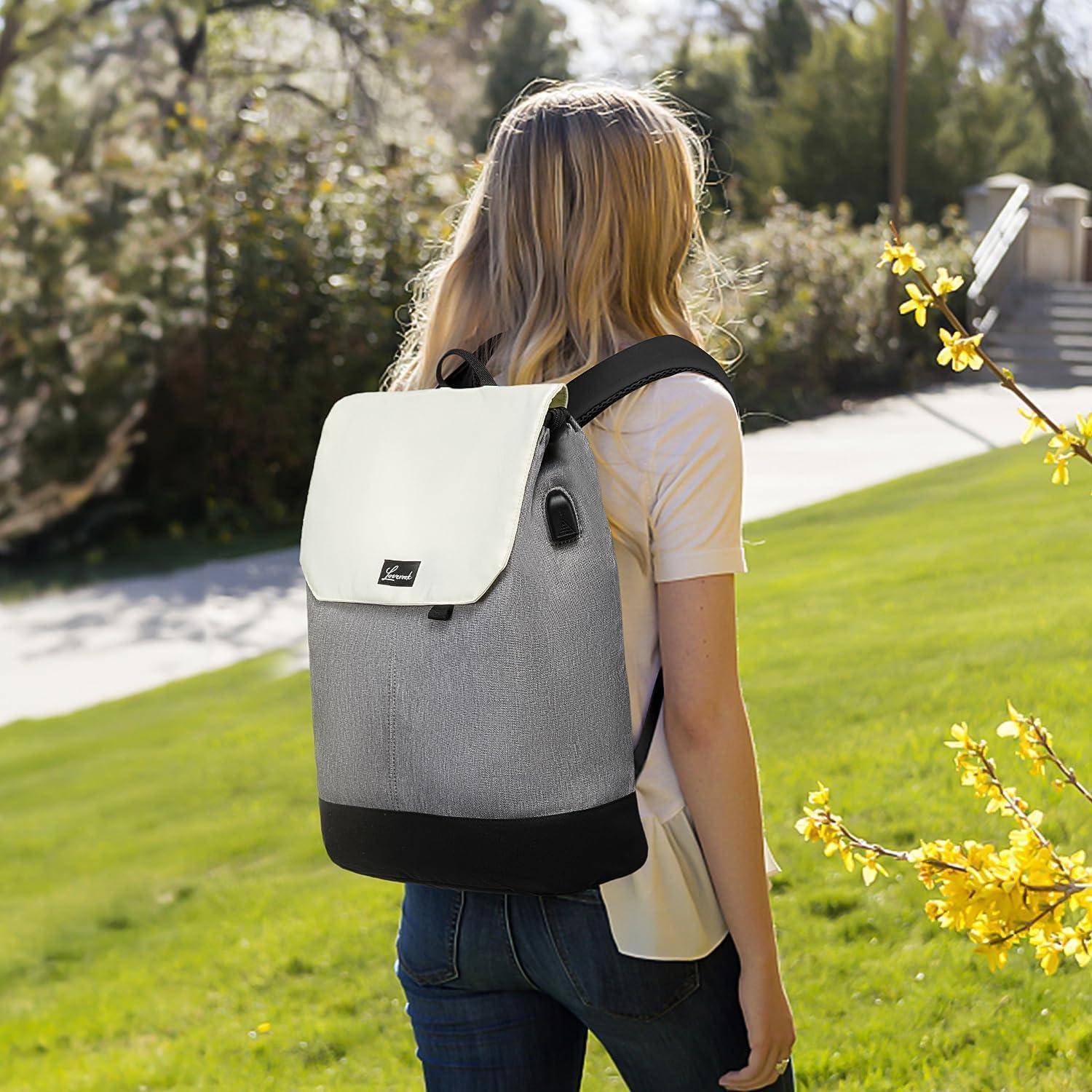 Eine Person mit langen Haaren, einen Rucksack tragend, steht auf einem sonnigen Weg, gesäumt von Bäumen und gelben Blumen in einer Parklandschaft.