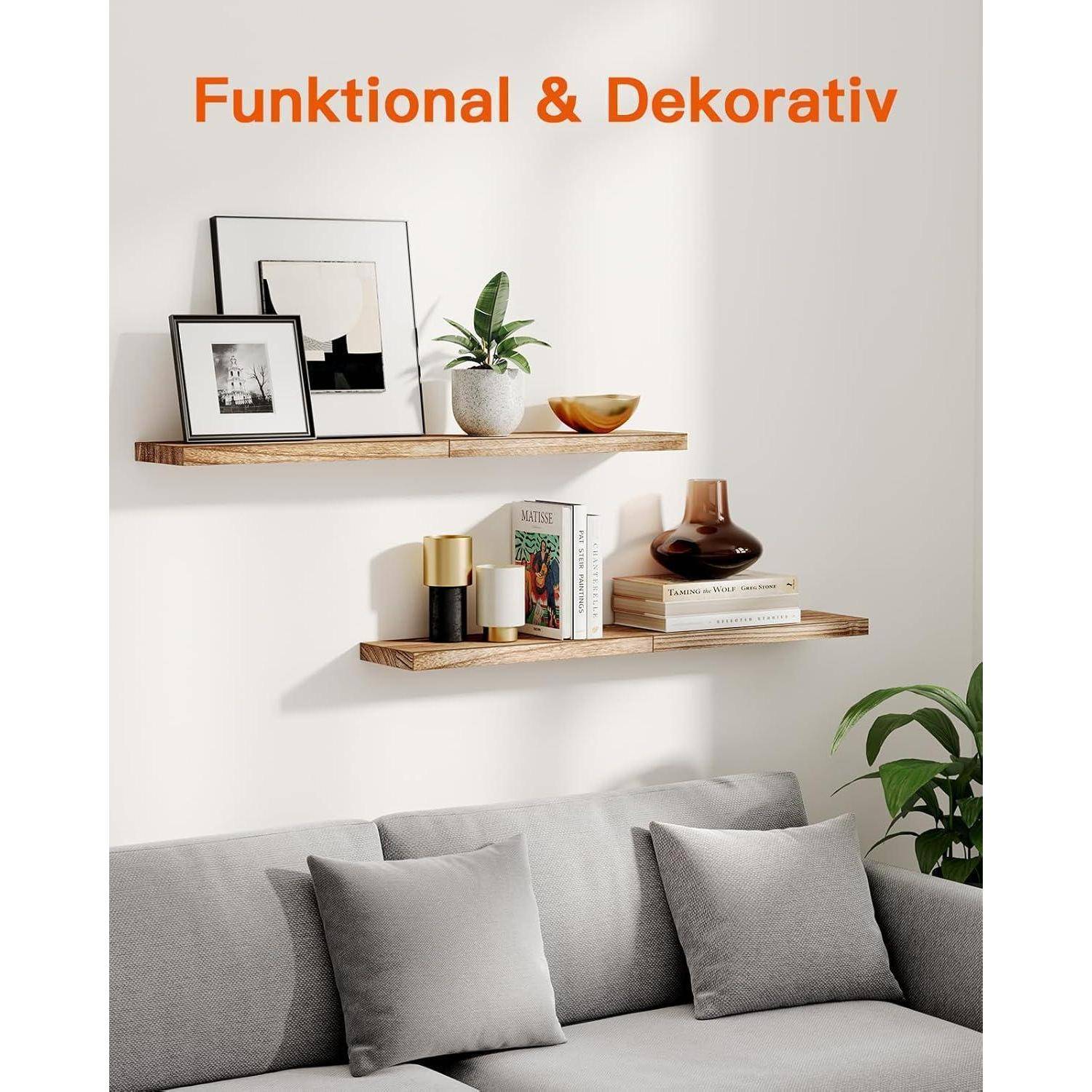 Wand mit zwei dekorativen Holzregalen, die gerahmte Kunstwerke, Pflanzen, eine Kerze und Vasen über einem grauen Sofa präsentieren. Text lautet 'Funktional & Dekorativ'.