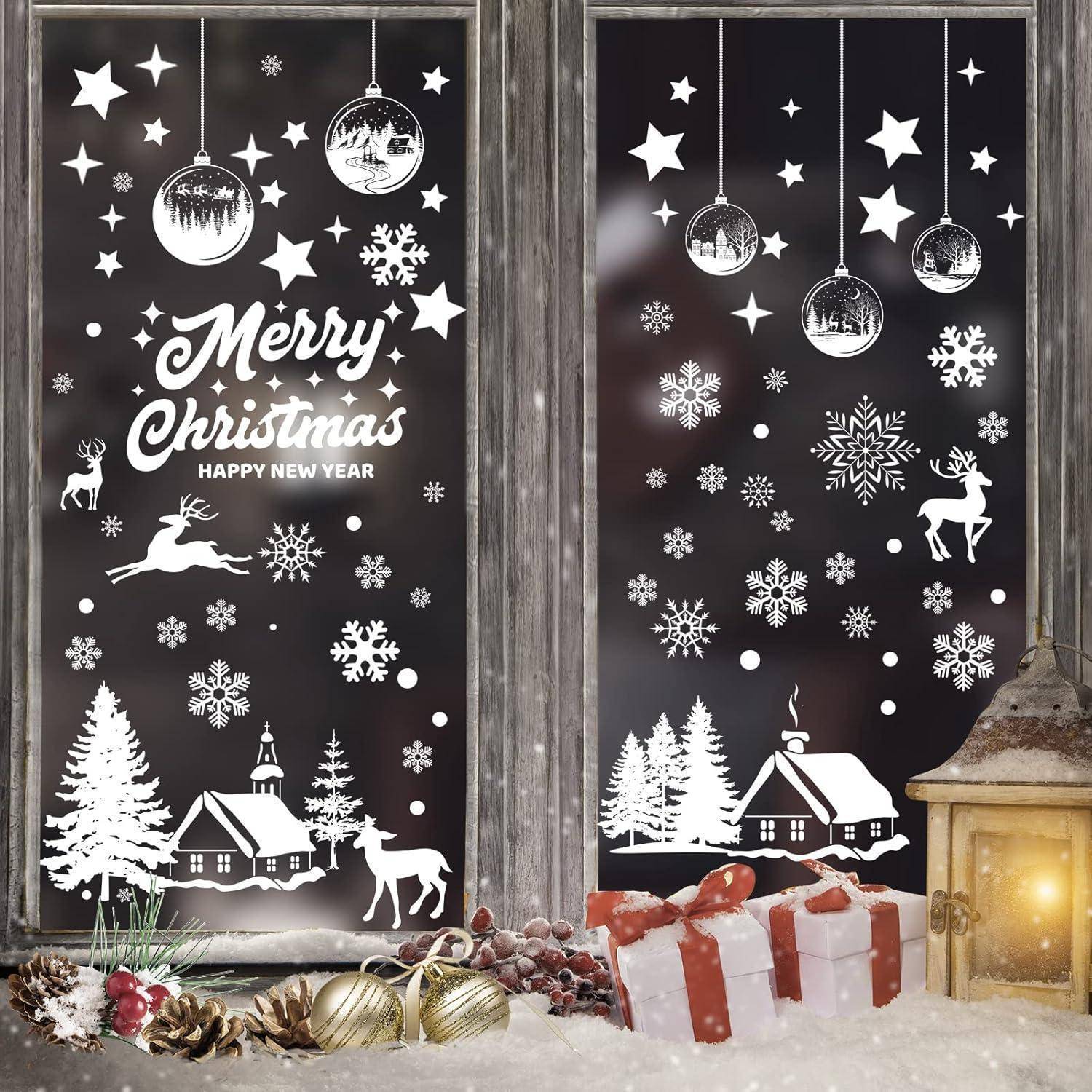 Fensterdekorationen mit weißen weihnachtlichen Illustrationen: Schneeflocken, Rentiere, Bäume und Häuser. Text lautet: 