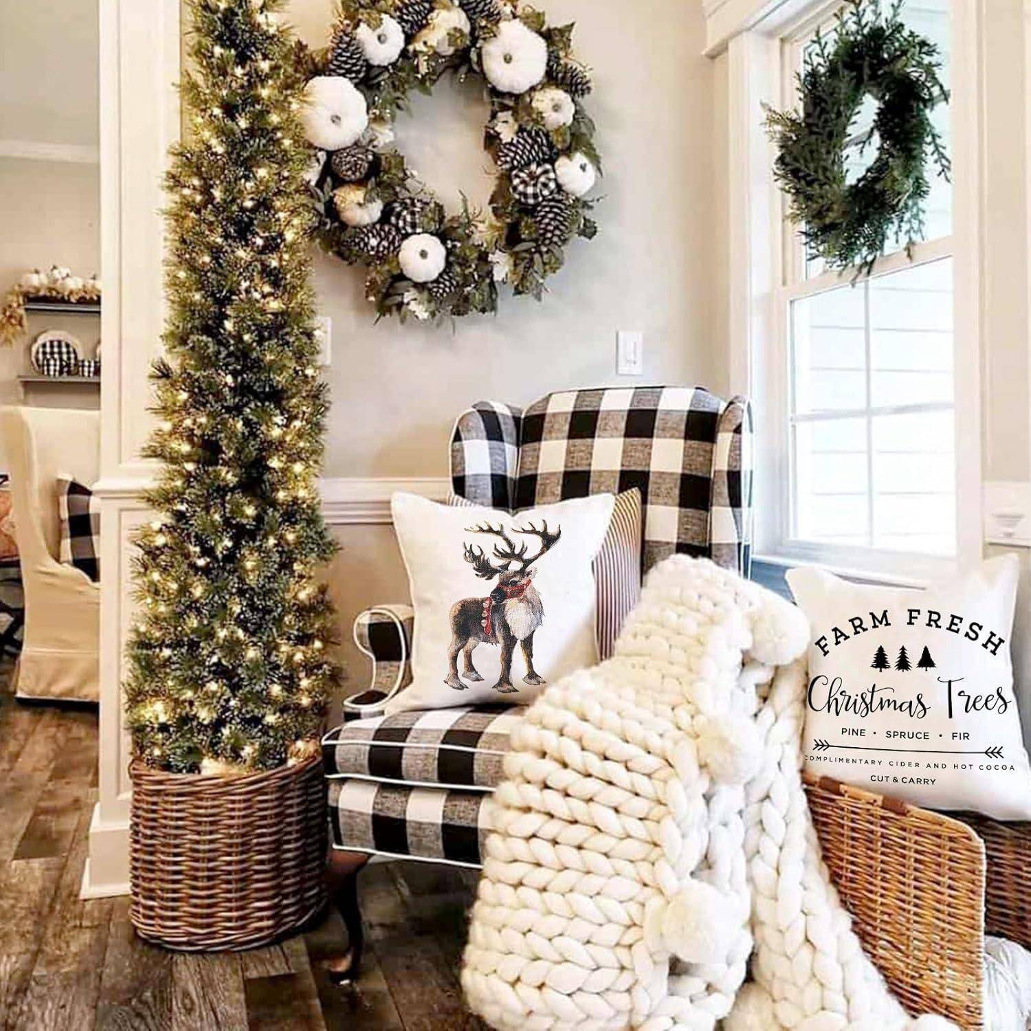 Ein gemütliches Weihnachts-Wohnzimmer mit einem kleinen, beleuchteten Weihnachtsbaum, einem karierten Sessel, einem Schild mit der Aufschrift „Farm Fresh Christmas Trees