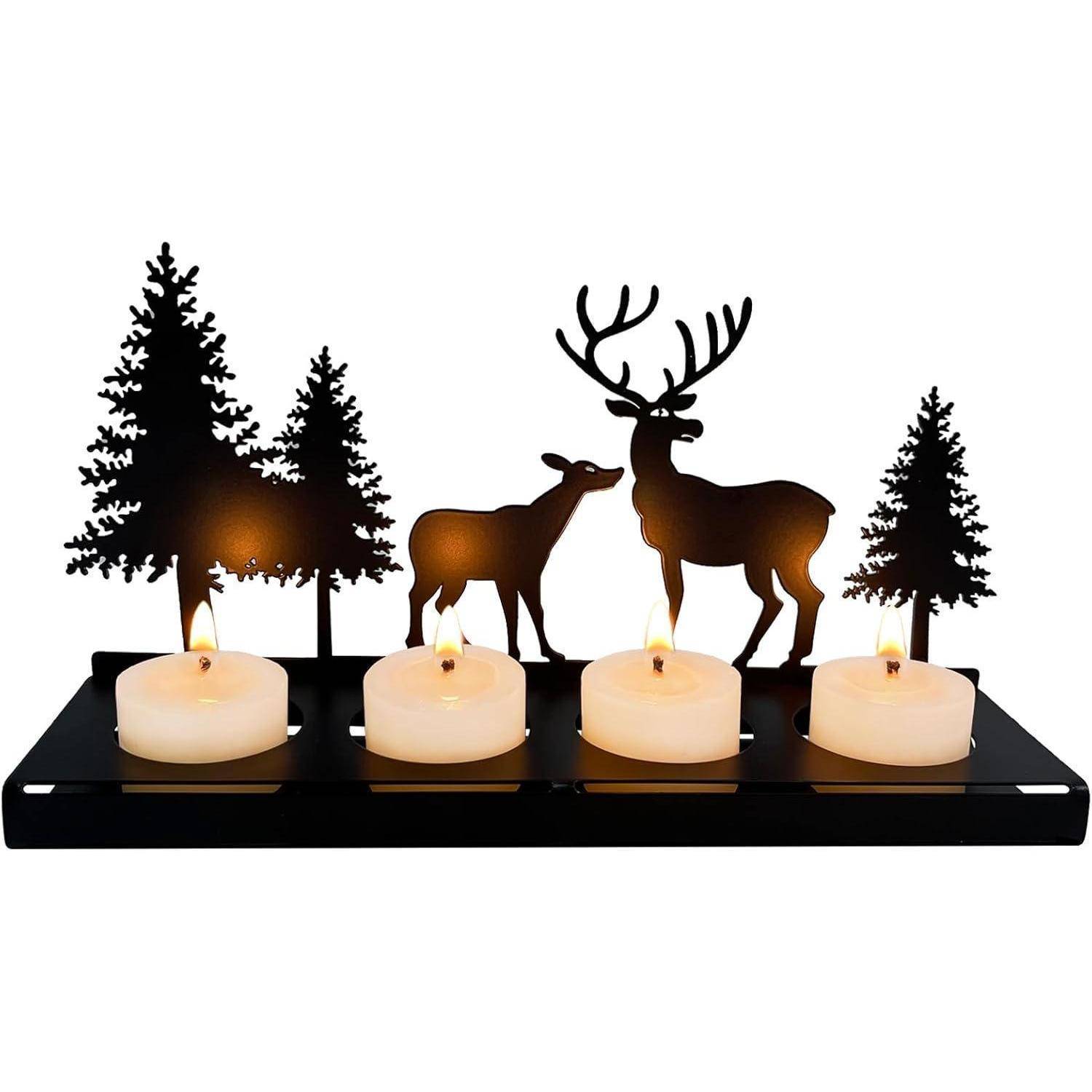 Ein Kerzenbehälter mit Silhouetten von Bäumen und Hirschen, mit vier brennenden weißen Kerzen in einer Reihe vor dem Design.