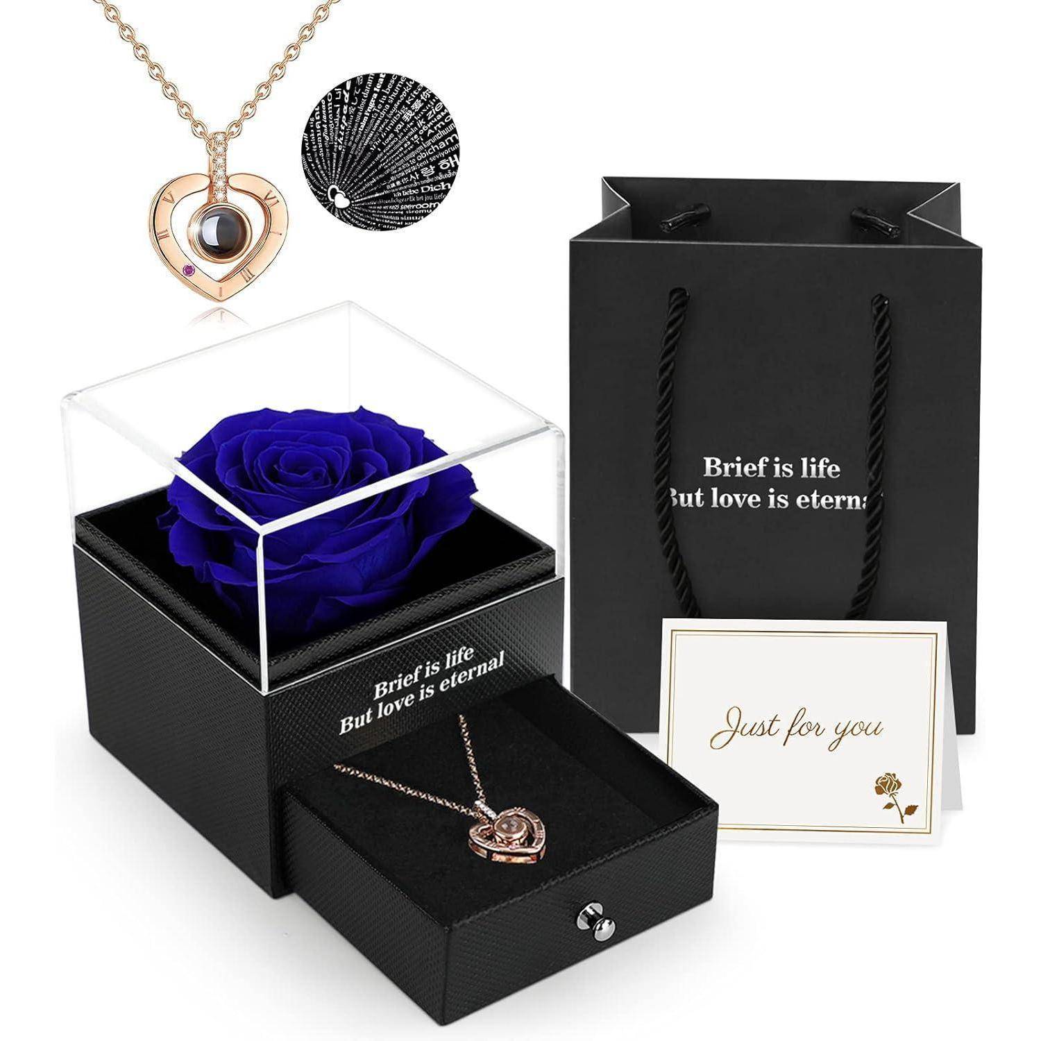 Blaue Rose in einer Box mit dem Text 'Das Leben ist kurz, Aber die Liebe ist ewig', Herz-Halskette, Geschenktüte, Karte mit der Aufschrift 'Nur für dich' daneben platziert.