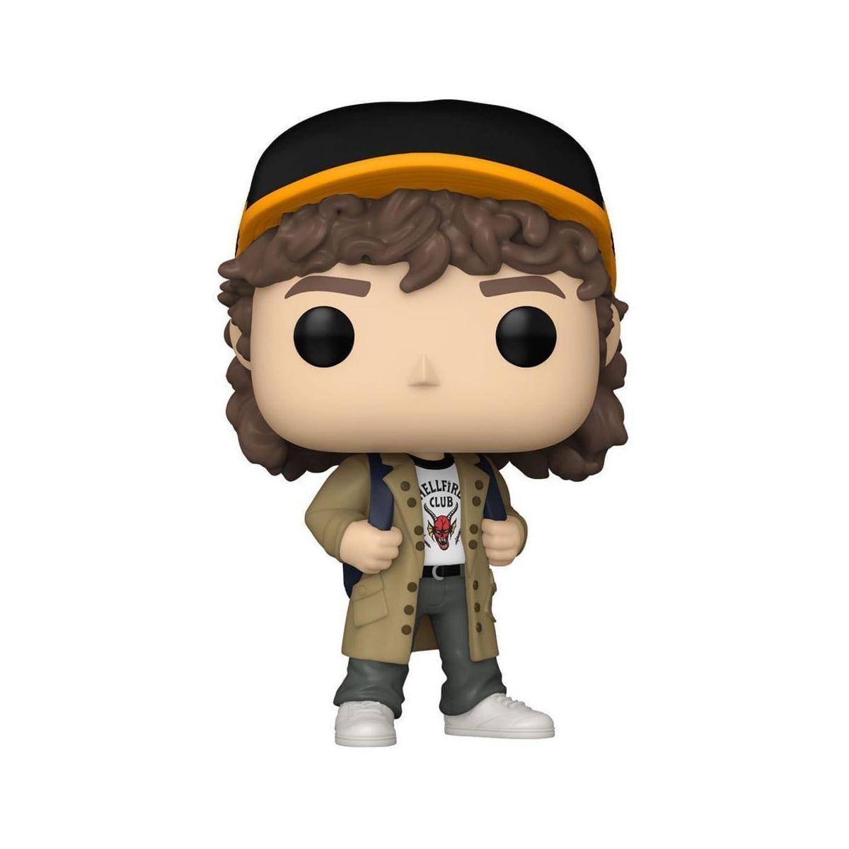 Eine Vinylfigur mit lockigem Haar, die eine Mütze trägt, einen langen Mantel, ein grafisches T-Shirt und Turnschuhe, die mit einer Hand in der Tasche stehen.