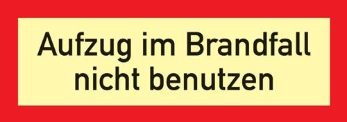 Ein Schild mit dem Text 'Zugang im Brandfall nicht benutzen' auf gelbem Hintergrund mit roten Umrandungen, das anzeigt, dass der Zugang im Brandfall nicht genutzt werden soll.