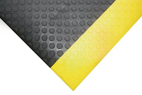 Nahaufnahme einer schwarzen und gelben strukturierten Bodenmatte mit kreisförmigen Griffen.