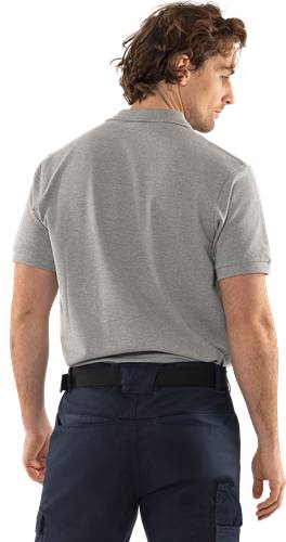Eine Person trägt ein graues Poloshirt und dunkle Hose, von hinten gesehen, mit seitlich herabhängenden Armen, vor einem schwarzen Hintergrund.