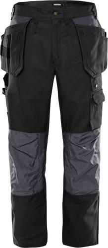 Das Bild zeigt eine Nahaufnahme von schwarzen Arbeitshorts mit mehreren Taschen, die für Funktionalität und Strapazierfähigkeit konzipiert sind und von einer Person getragen werden.