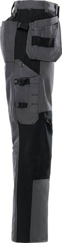 Eine Person trägt graue Hosen mit schwarzen Details, die eine Tasche und Seitennähte zeigen. Der Fokus liegt auf der Textur und den Designelementen.
