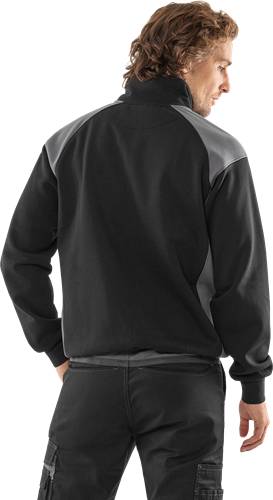 Eine Person, die von hinten gesehen wird, trägt eine schwarz-graue Jacke.