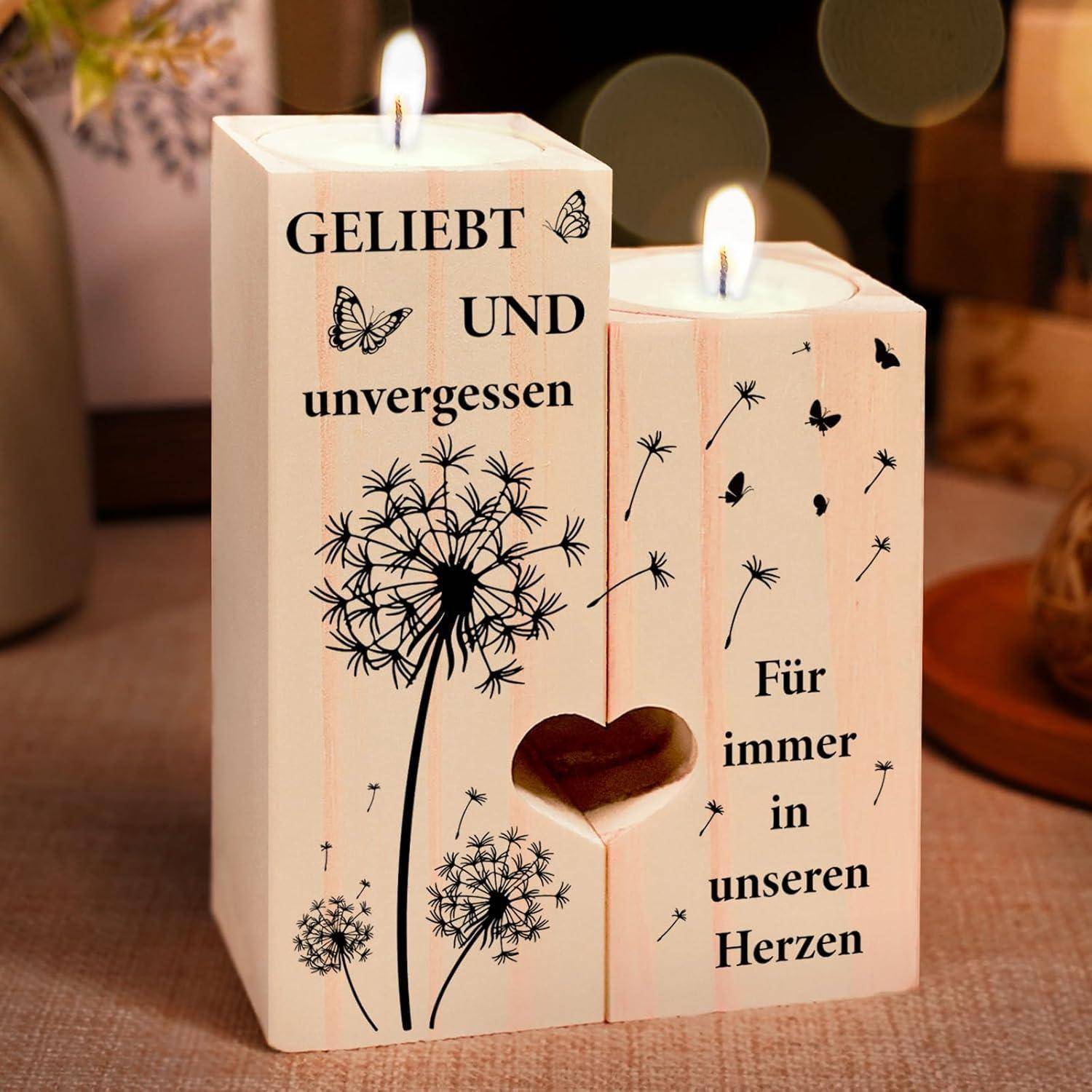 Zwei Kerzenhalter aus Holz mit brennenden Kerzen, geschmückt mit Löwenzahn und Schmetterlingen. Text lautet: 