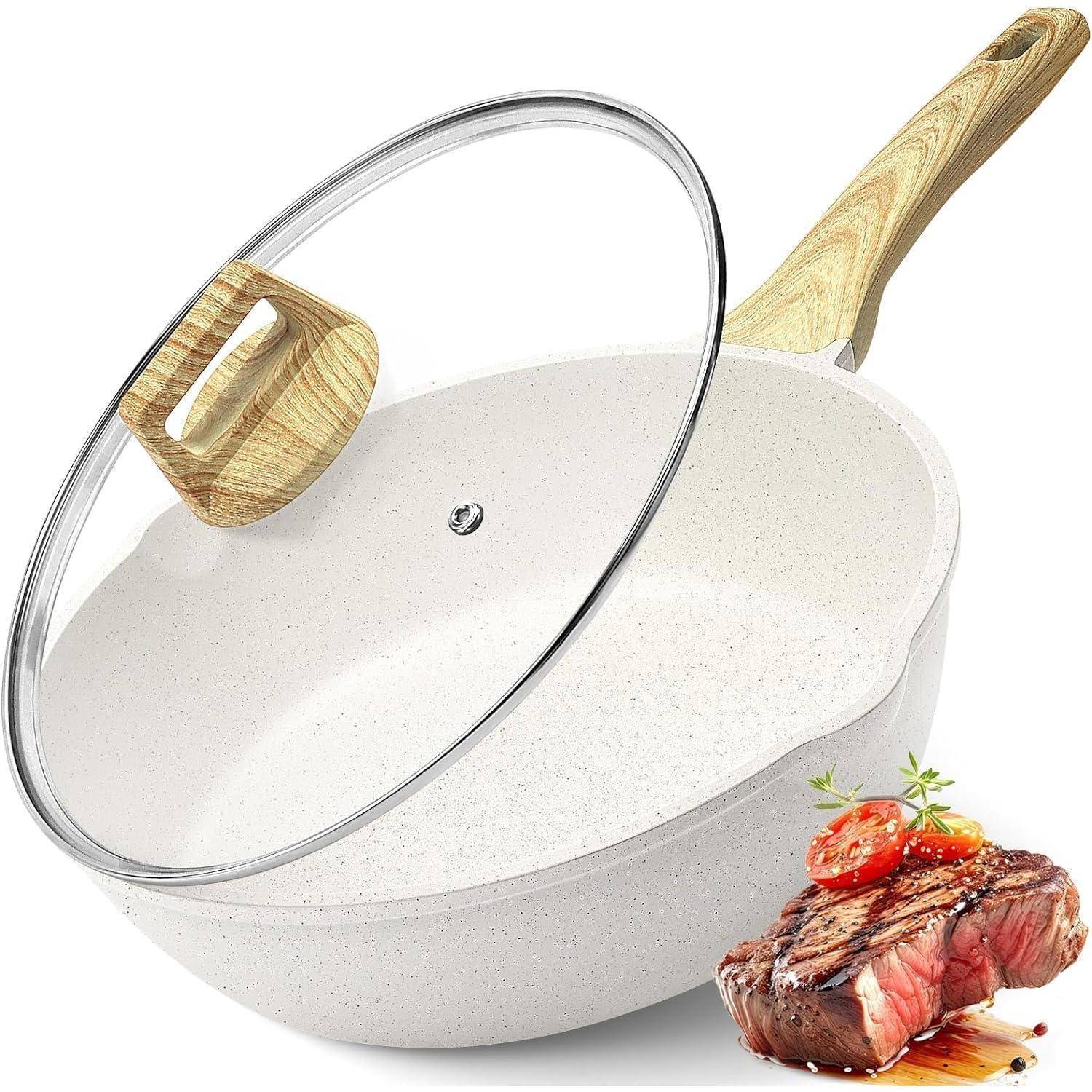 Eine weiße Antihaft-Bratpfanne mit Holzgriff und Glasdeckel, auf der ein gebratenes Steak mit Beilage platziert ist.