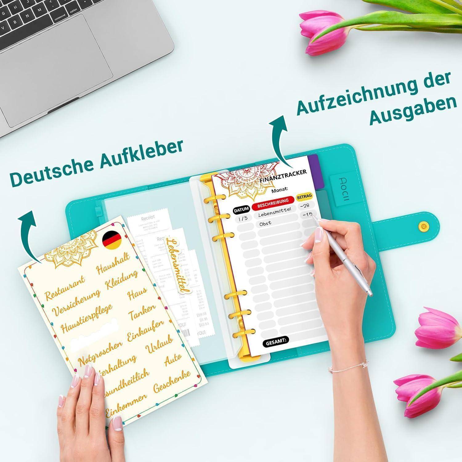 Eine Person, die in einem deutschen Ausgaben-Tracker-Notizbuch schreibt, umgeben von einem Laptop, dekorativen Stickern und Tulpen.