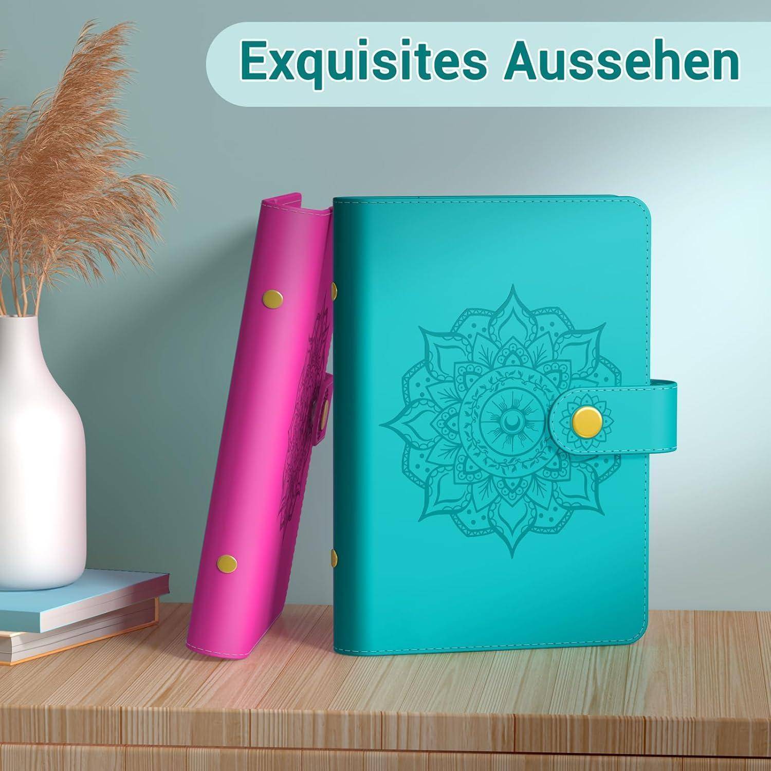 Zwei dekorative Notizbücher, eines in Rosa, das andere in Türkis mit Mandala-Muster, stehen aufrecht auf einem Tisch neben einer Vase mit Pampasgras. Der deutsche Text lautet 'Exquisites Aussehen.
