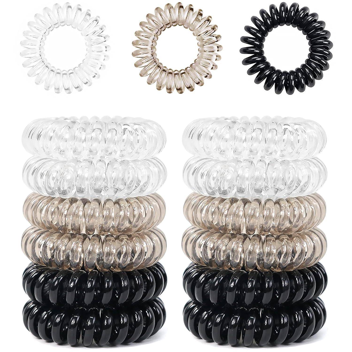 Ein Set von Spiral-Haarbändern in transparenten, braunen und schwarzen Farben, in Stapeln von je drei Stück pro Farbe präsentiert.