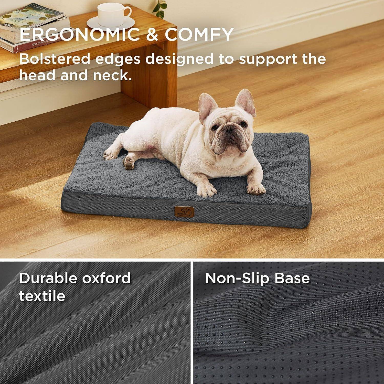 Ein Französische Bulldogge liegt entspannt auf einem grauen Haustierbett mit erhöhten Kanten. Der Text hebt die Merkmale hervor: 'Ergonomisch & Bequem', 'Strapazierfähiger Oxford-Stoff', 'Rutschfeste Unterseite'.