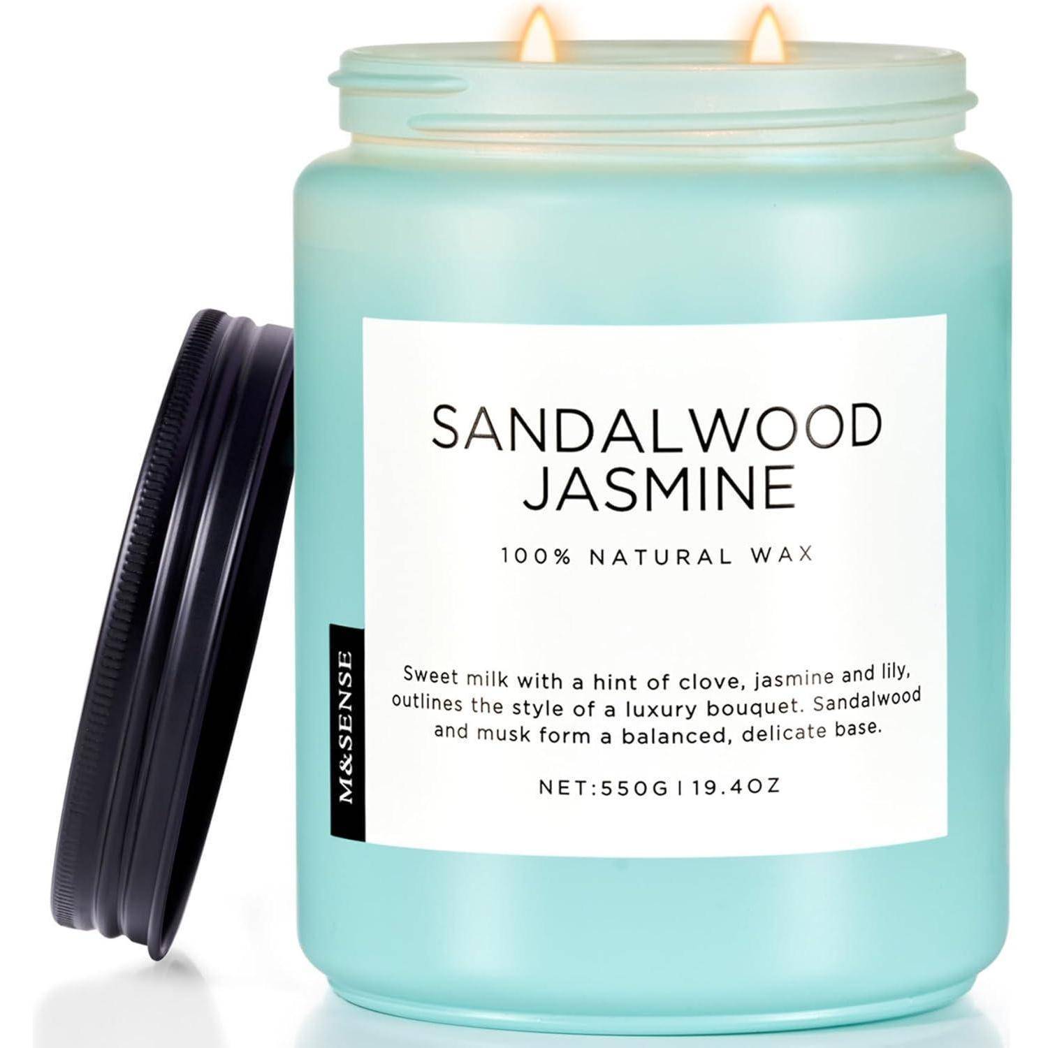 Eine Kerze im Glas mit der Aufschrift 'Sandelholz Jasmin' mit der Beschreibung 'Süße Milch mit einer Spur von Nelke, Jasmin und Lilie' und '550g/19,4 oz'.