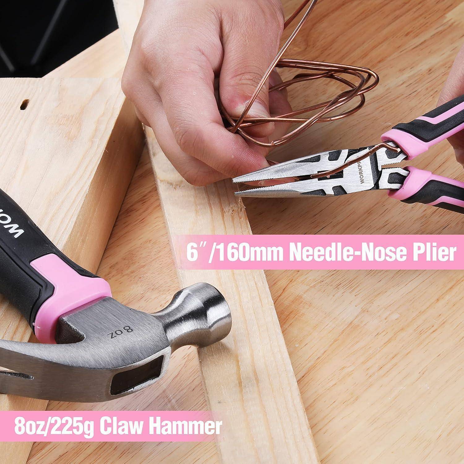 Eine Hand benutzt eine rosa-schwarze Nadel-Zange, um einen Draht auf einer Holzoberfläche zu verdrehen. Ein Klauenhammer liegt in der Nähe. Etiketten zeigen die Werkzeuggrößen an.