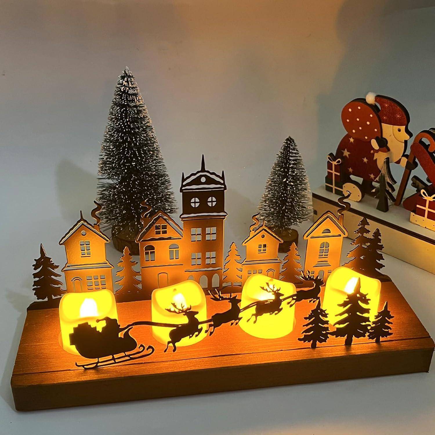 Eine festliche Holzdekoration, die eine winterliche Dorfszene darstellt, mit beleuchteten Häusern, Bäumen und der Silhouette von Santas Schlitten, der von Rentieren gezogen wird.