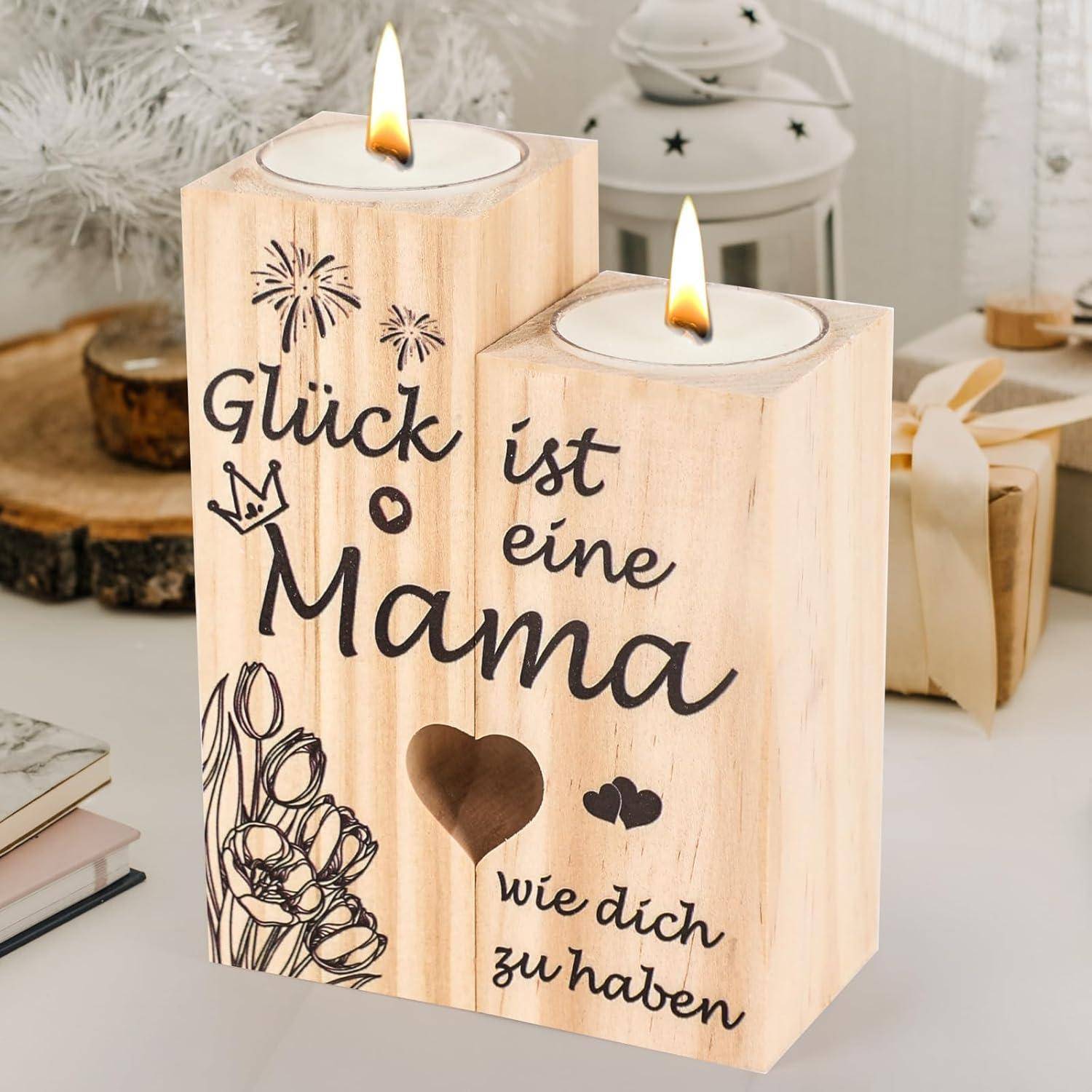 Zwei Holz-Kerzenhalter mit angezündeten Teelichtern. Einer trägt die Aufschrift 'Glück ist eine Mama wie dich zu haben', umgeben von dekorativen Zeichnungen.
